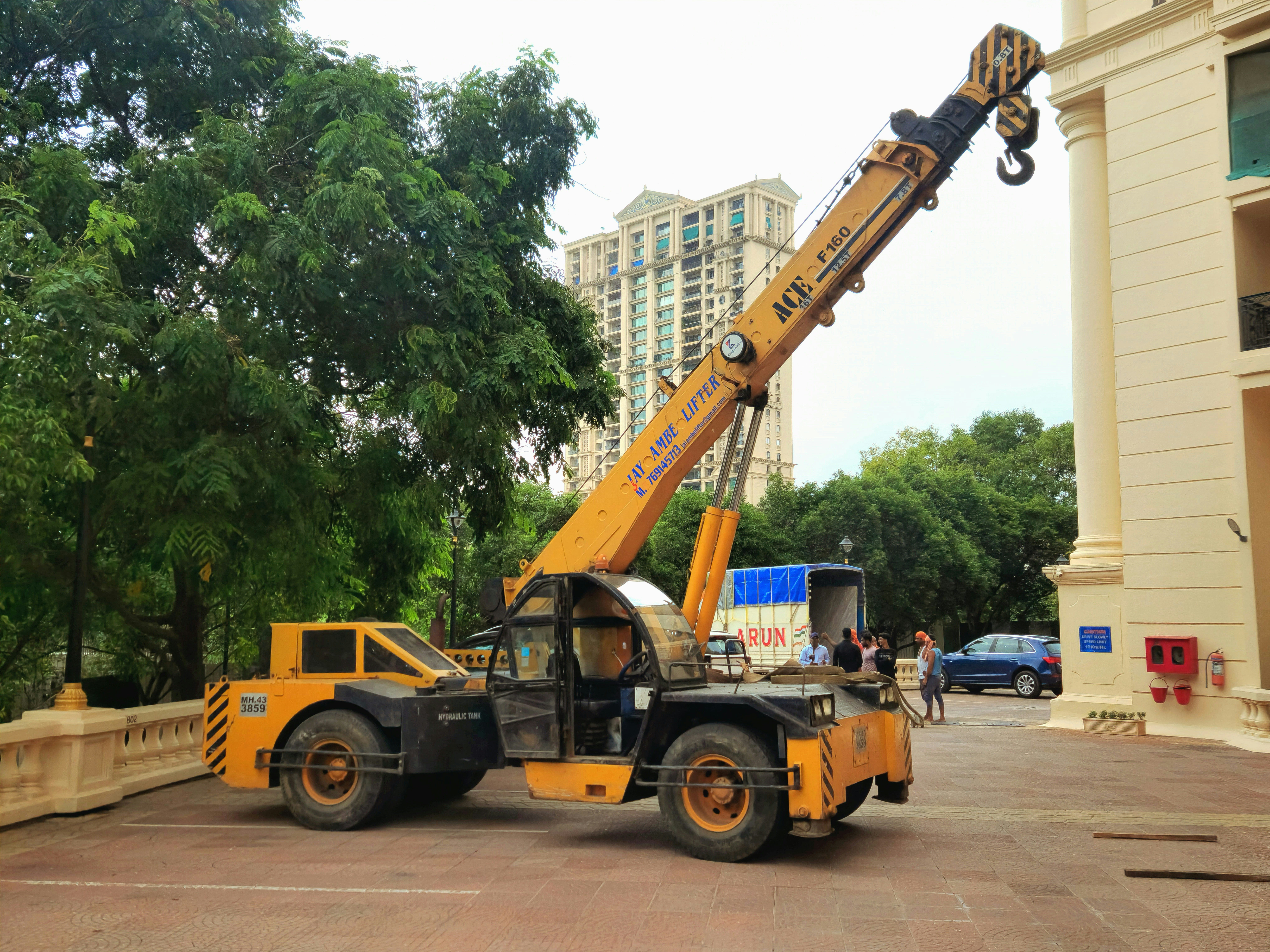 A mobile crane is parked near a building.