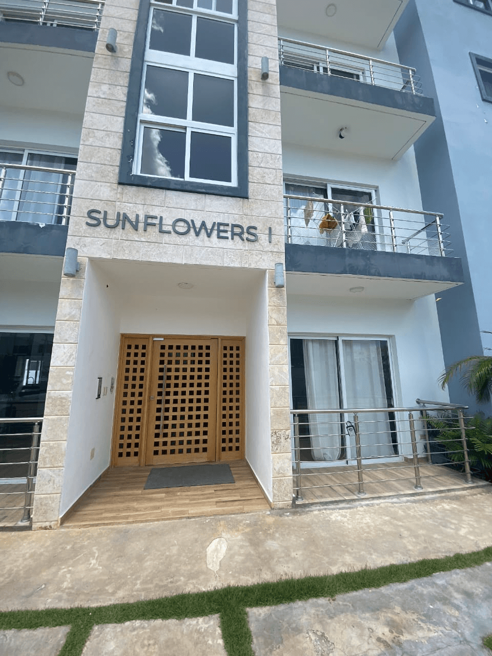 A modern brick house with a two-car garage, well-manicured lawn, and clear blue sky in the background.