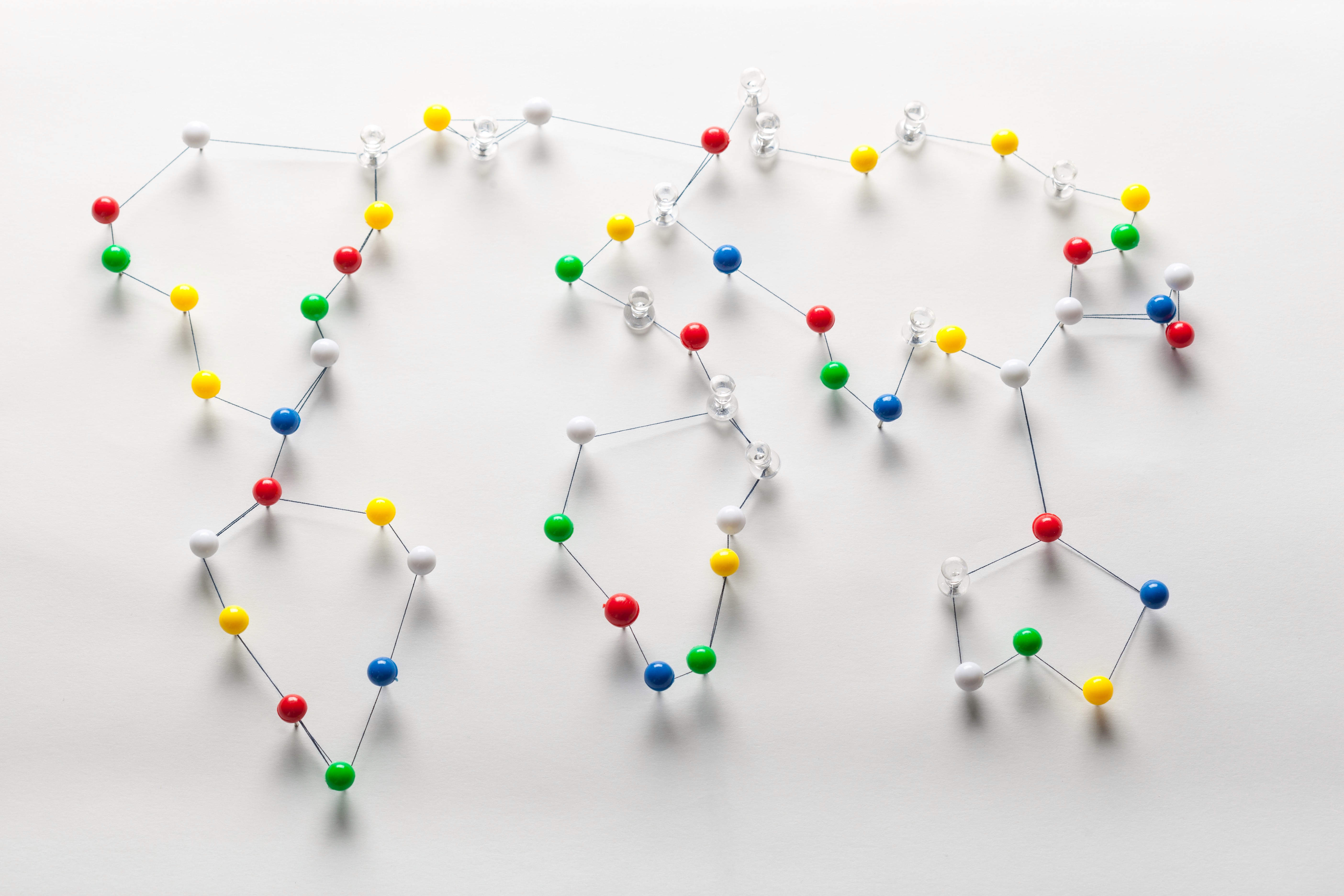 A world map formed from coloured pushpins connected by thread, representing the international collaborative network behind the NEC Registry.