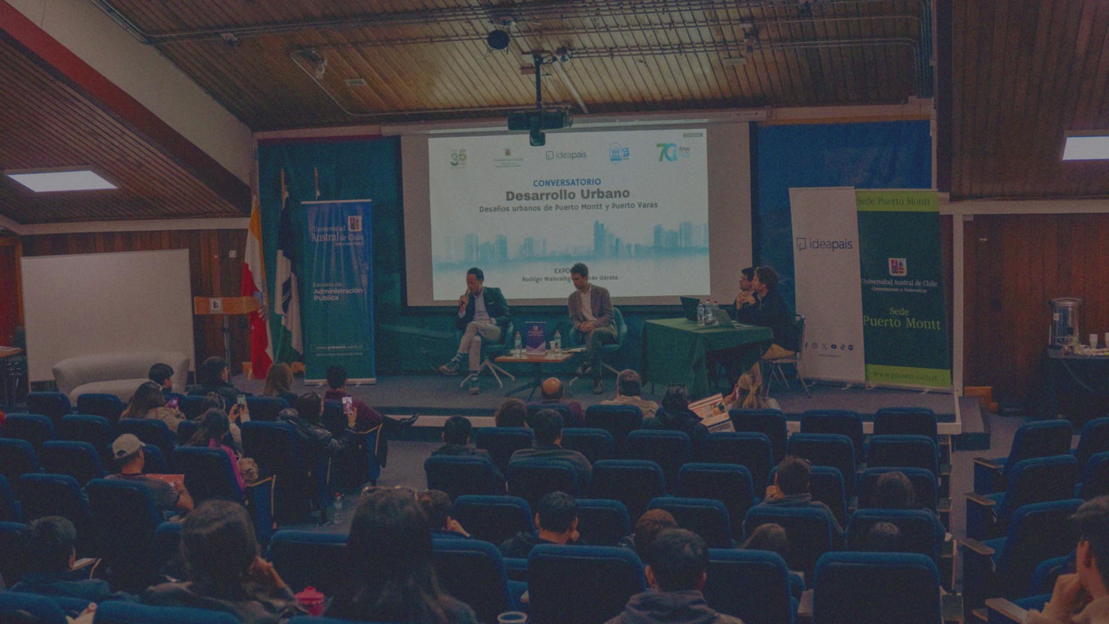 Foto del panel del conversatorio Desarrollo Urbano y sus asistentes en la Universidad Austral de Chile Sede Puerto Montt en la actividad organizada por IdeaPaís.