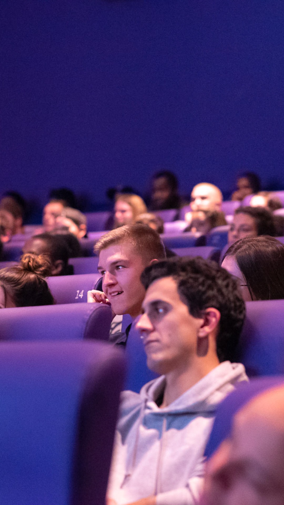 Modern home office setup with a monitor, ergonomic chair, keyboard, and indoor plants near a window with blinds.