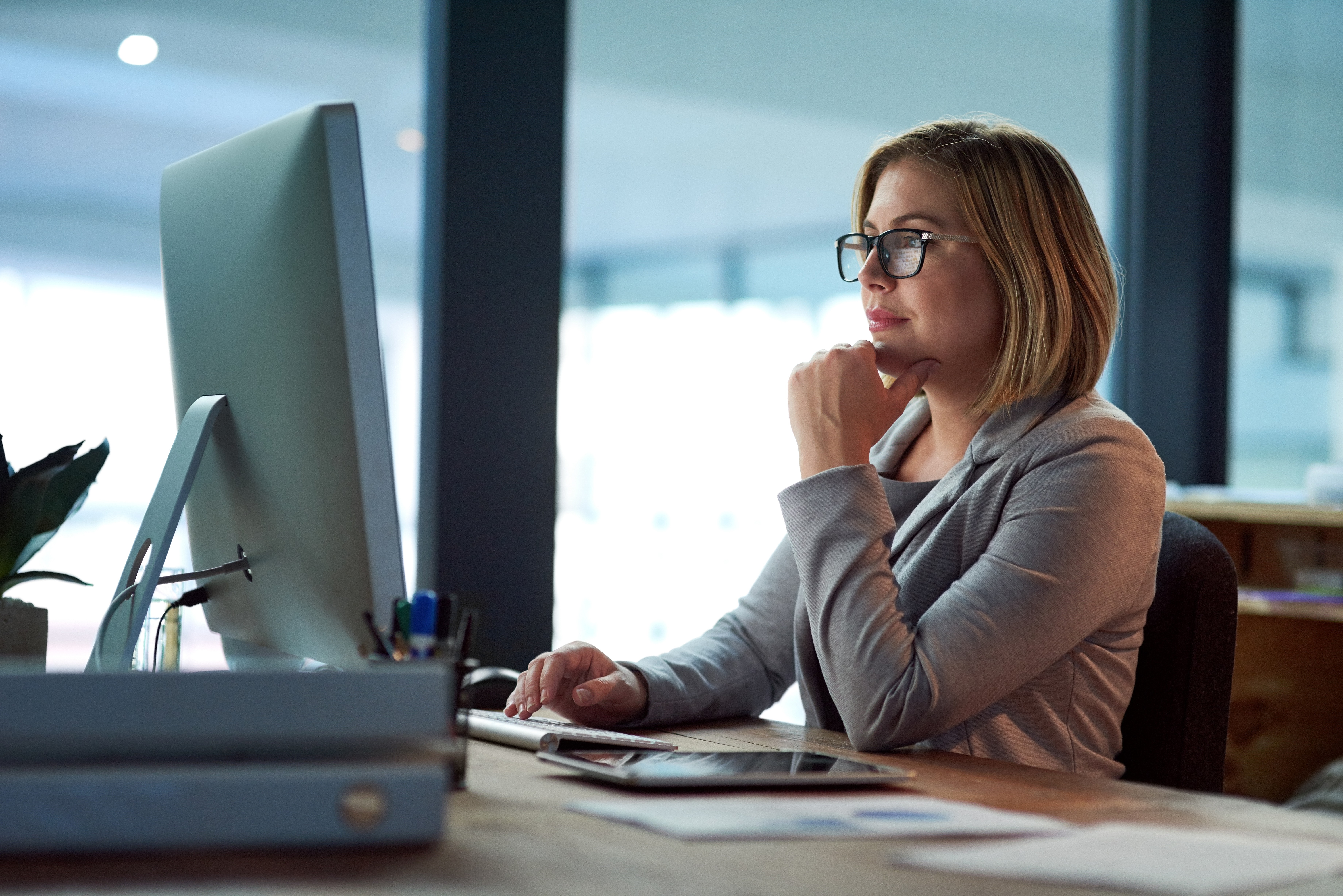 woman sitting around table holding tablet