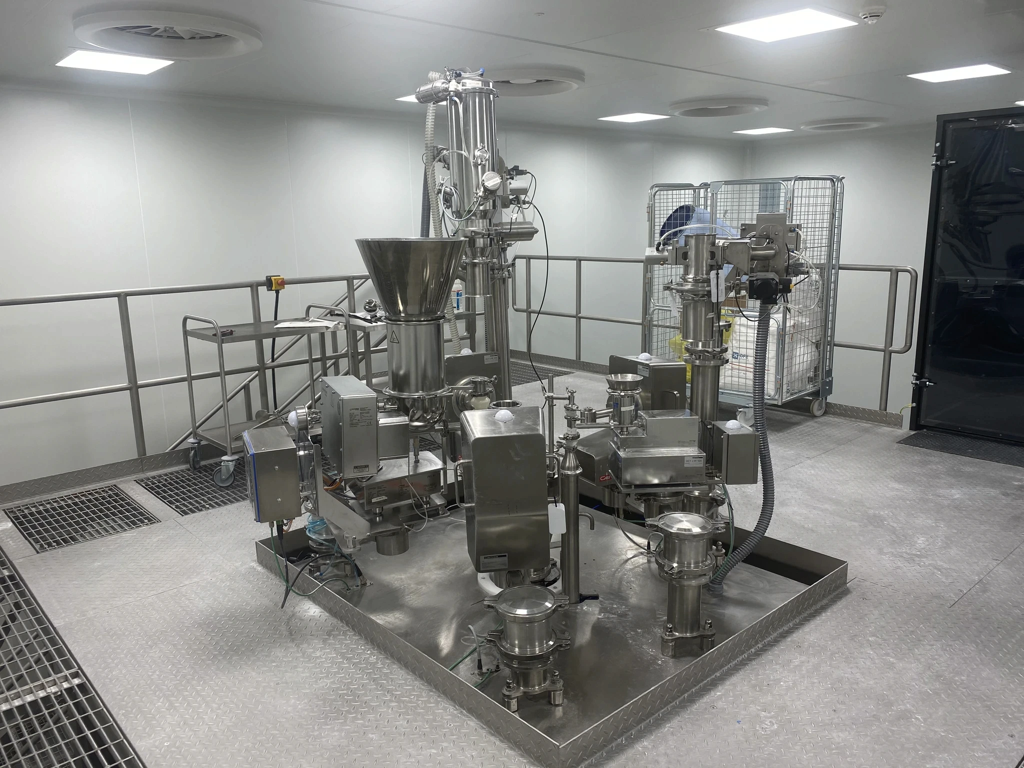 Stainless steel process equipment skid installed in a pharmaceutical cleanroom.