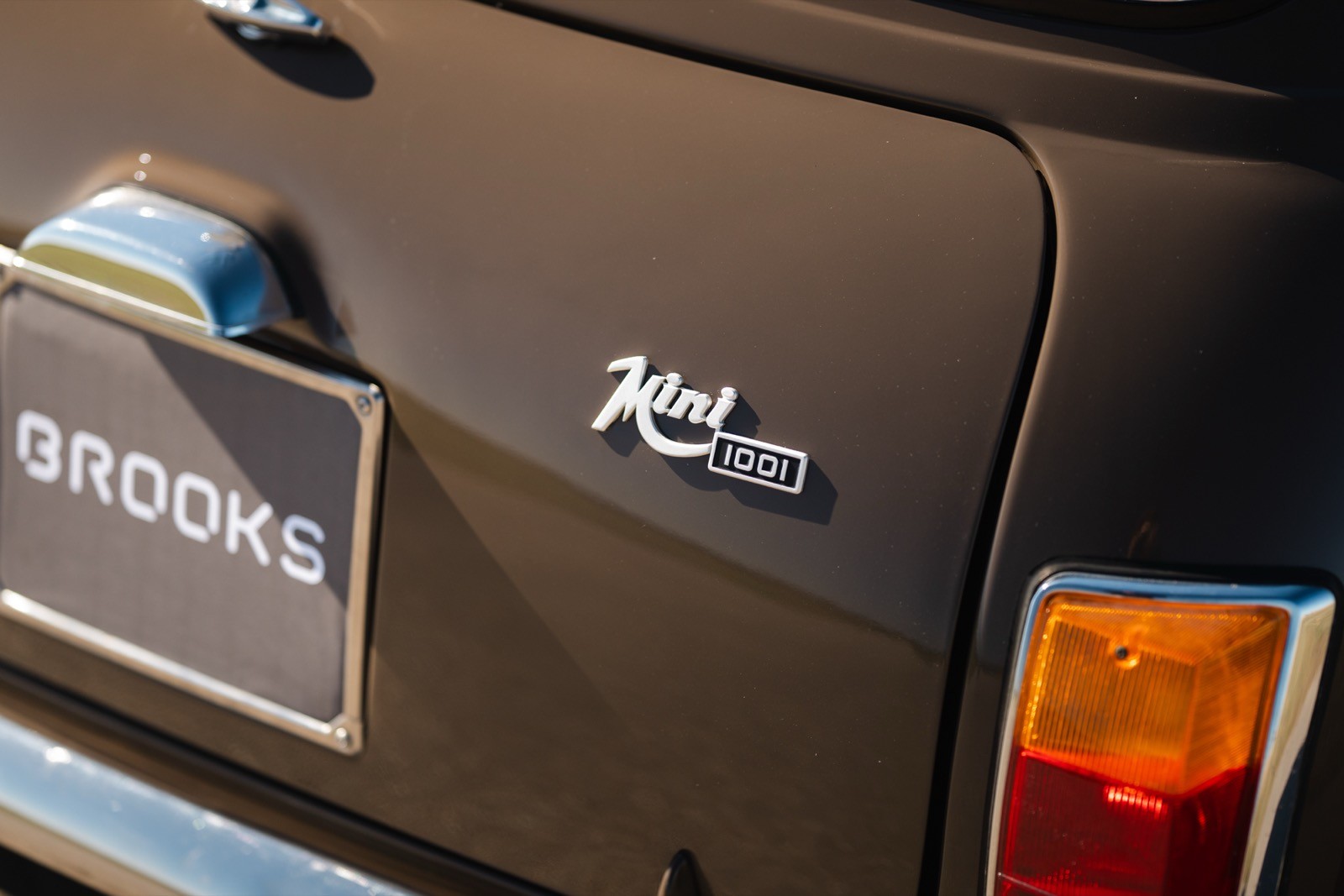 Close-up of a vehicle's rear, featuring the model name and taillight on a dark-colored surface.