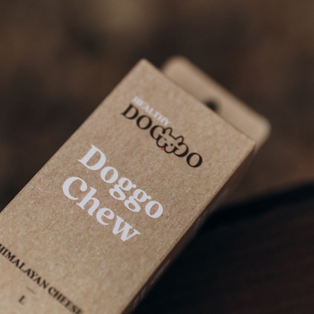 Modern home office setup with a monitor, ergonomic chair, keyboard, and indoor plants near a window with blinds.