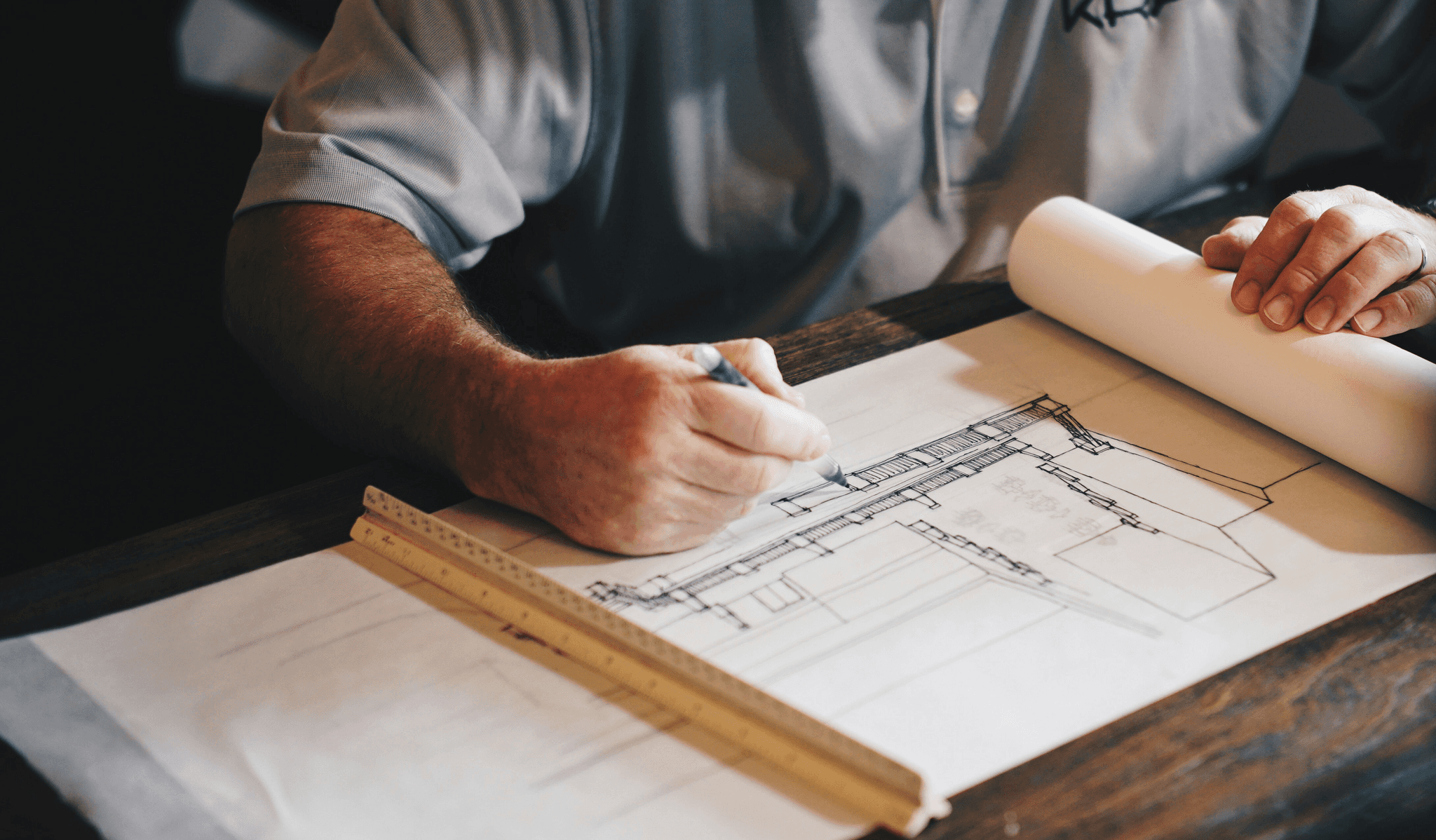 An architect working on a draft with a pencil and ruler