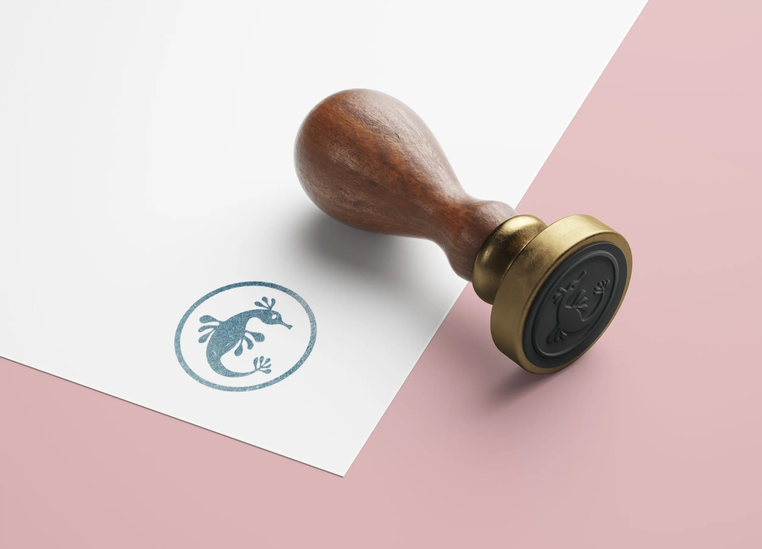 A wooden stamp rests beside a piece of paper featuring a circular seal on a light pink background.