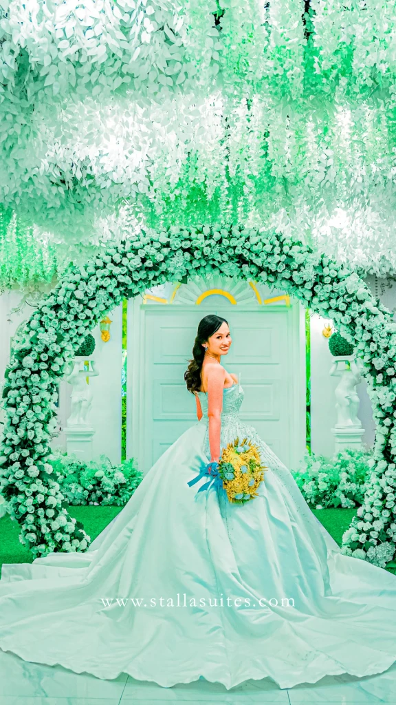 Bride in a mint gown framed by the wisteria arch at Celestia Hall