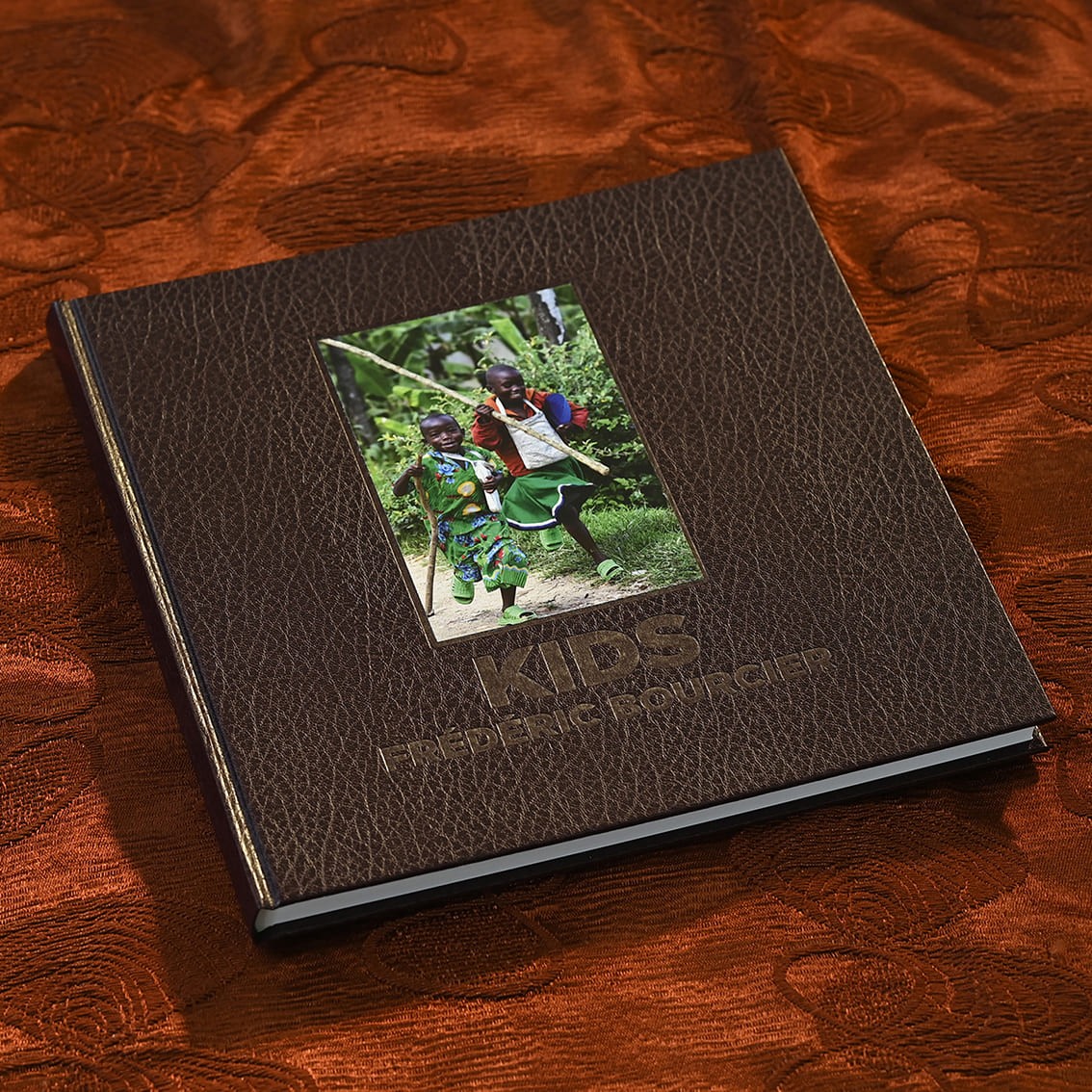 Livre photo Kids de Frédéric Bourcier, à couverture marron avec une photo d’enfants jouant à la balançoire.