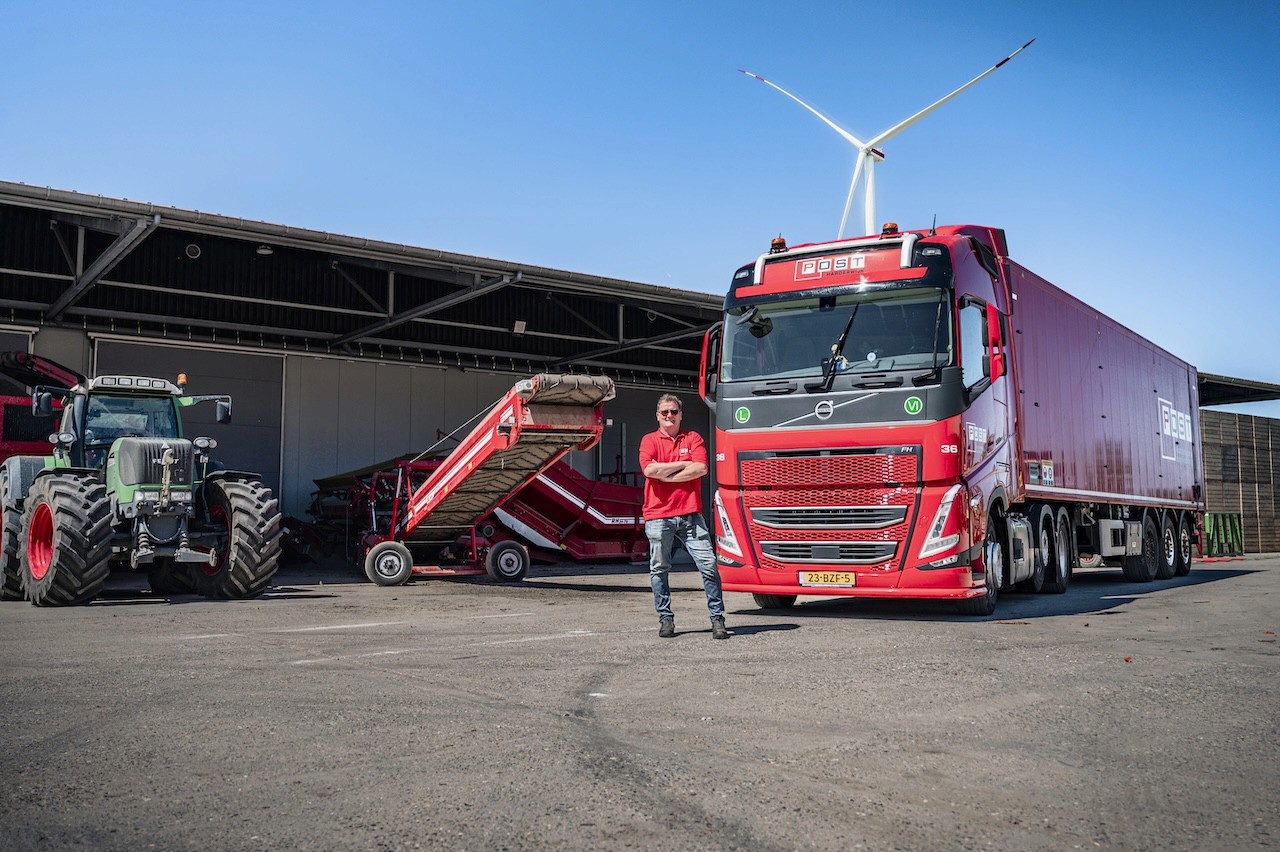 Chauffeur naast vrachtwagen Post Handel en Transport