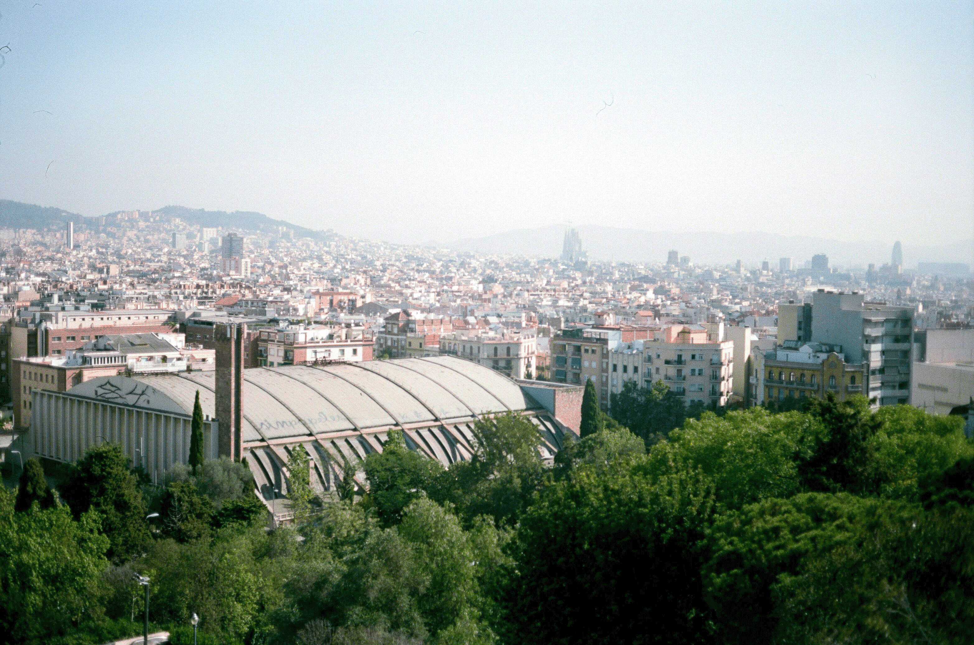 Panoramisch uitzicht vanaf Montjuïc over de stad Barcelona, met iconische bezienswaardigheden op de achtergrond.