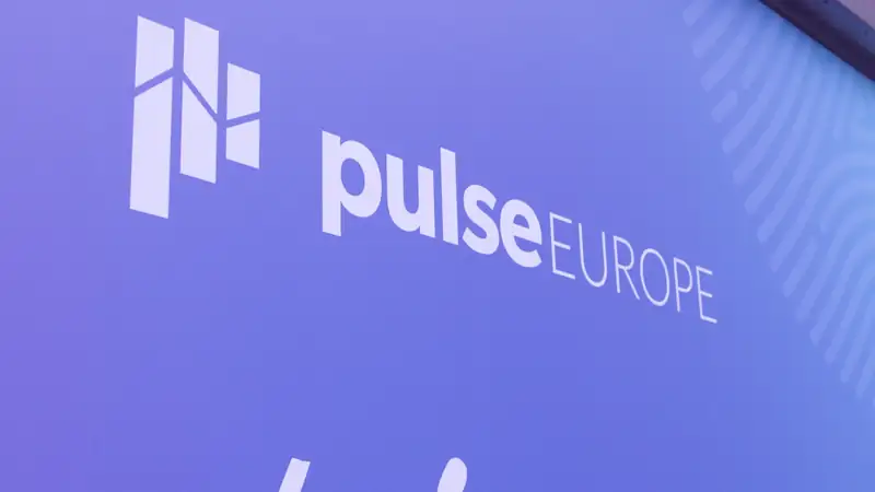 Keynote speaker presenting on a large stage with colourful event screens at Gainsight Pulse.