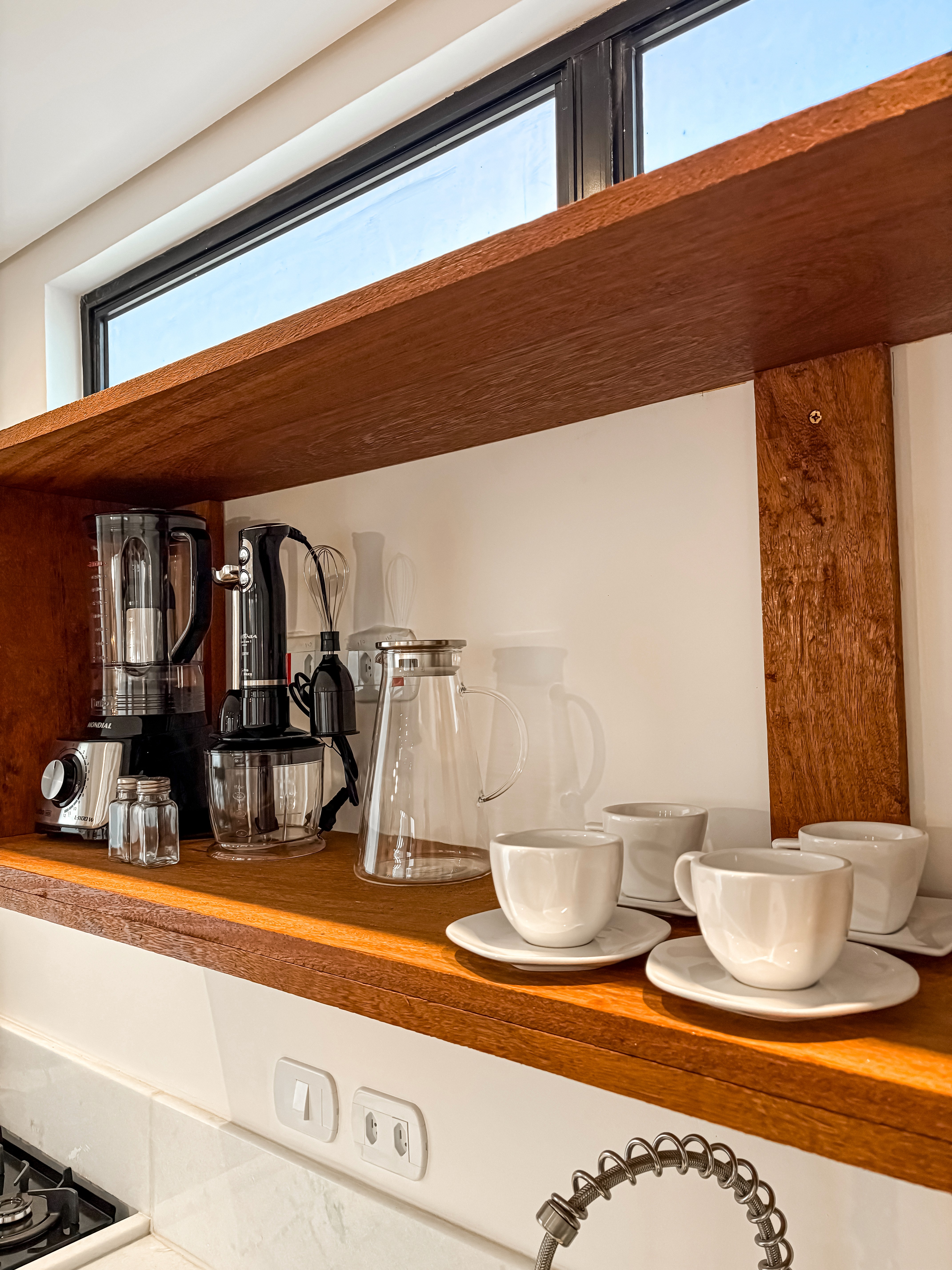 sleeping and living areas, king bed with layered neutral linens, elegant reading lights, and modern sofa with textured cushions