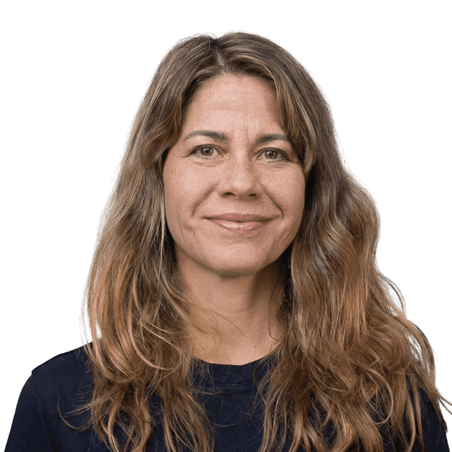 Woman with long brown hair smiling. Studio portrait against black background.