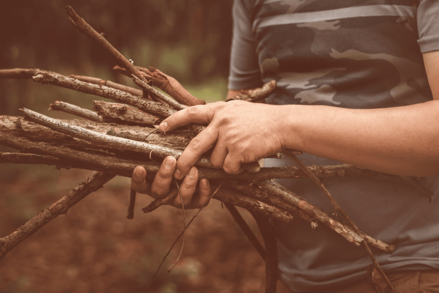 A man alone in the woods gathering firewood