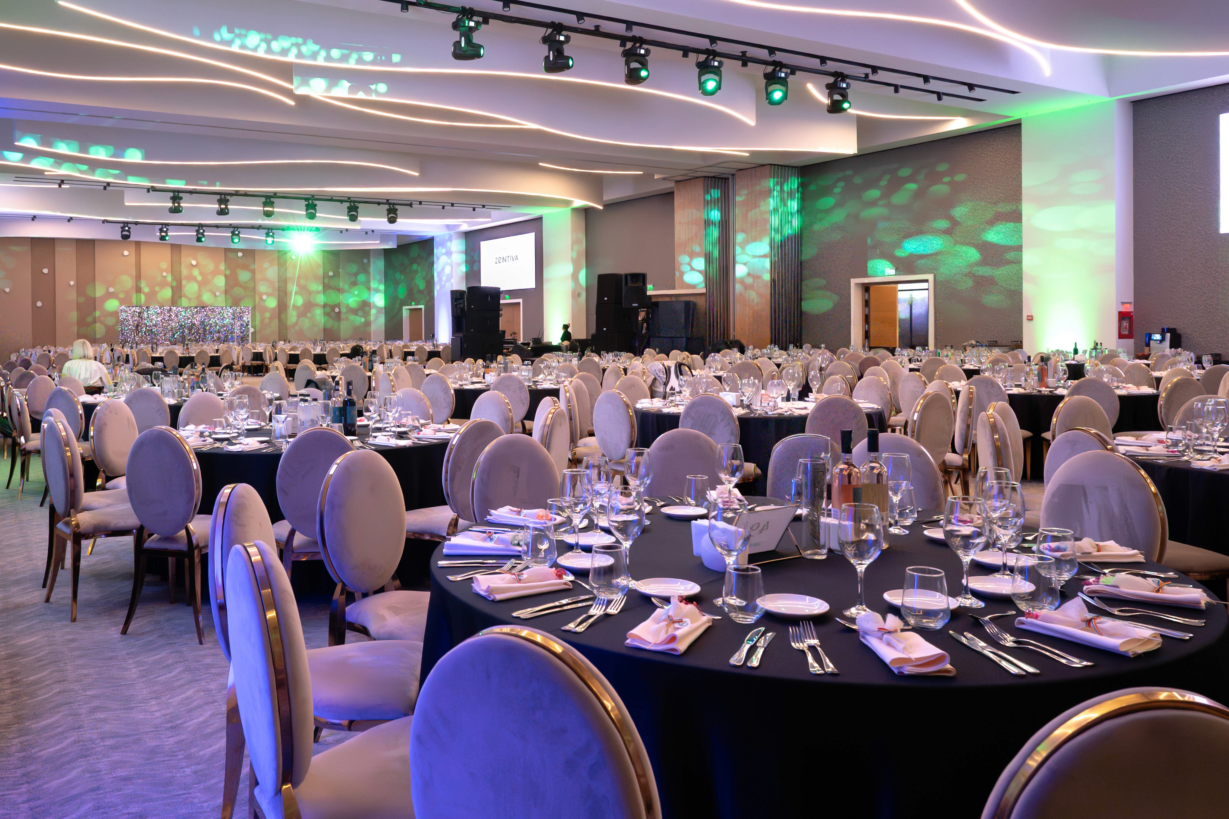 Sala principală pregătită pentru petrecerea corporate de Crăciun la Zooma Events Corbeanca, cu mese rotunde și iluminare ambientală — fotograf eveniment corporate București.