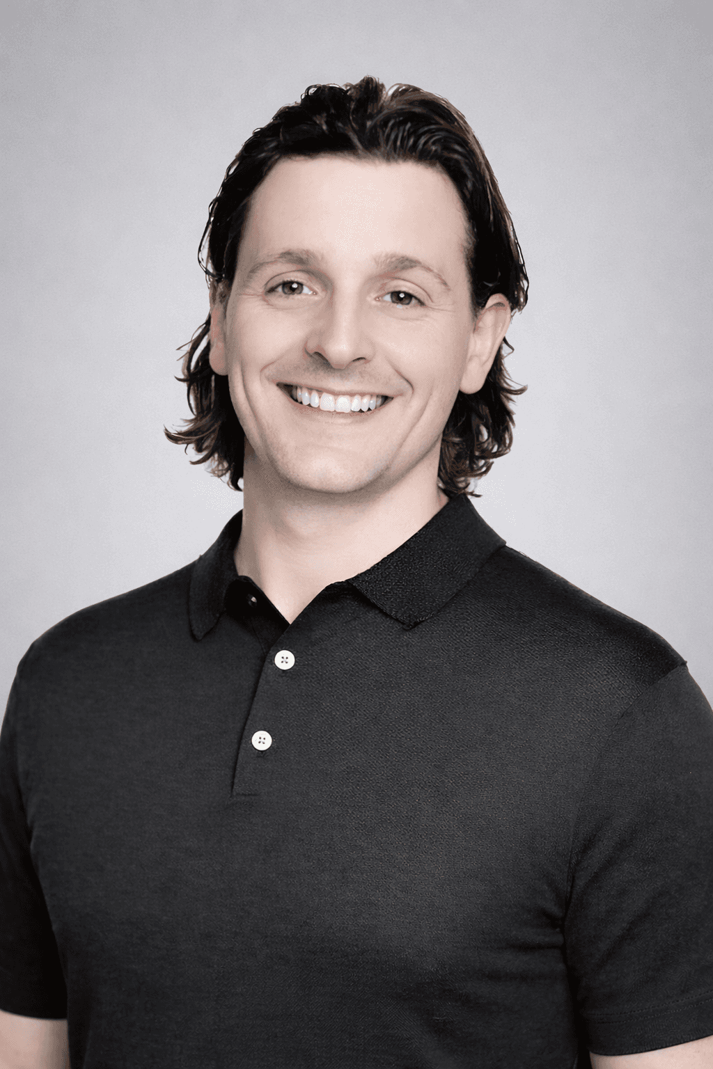 Black and white portrait of a smiling person with curly hair