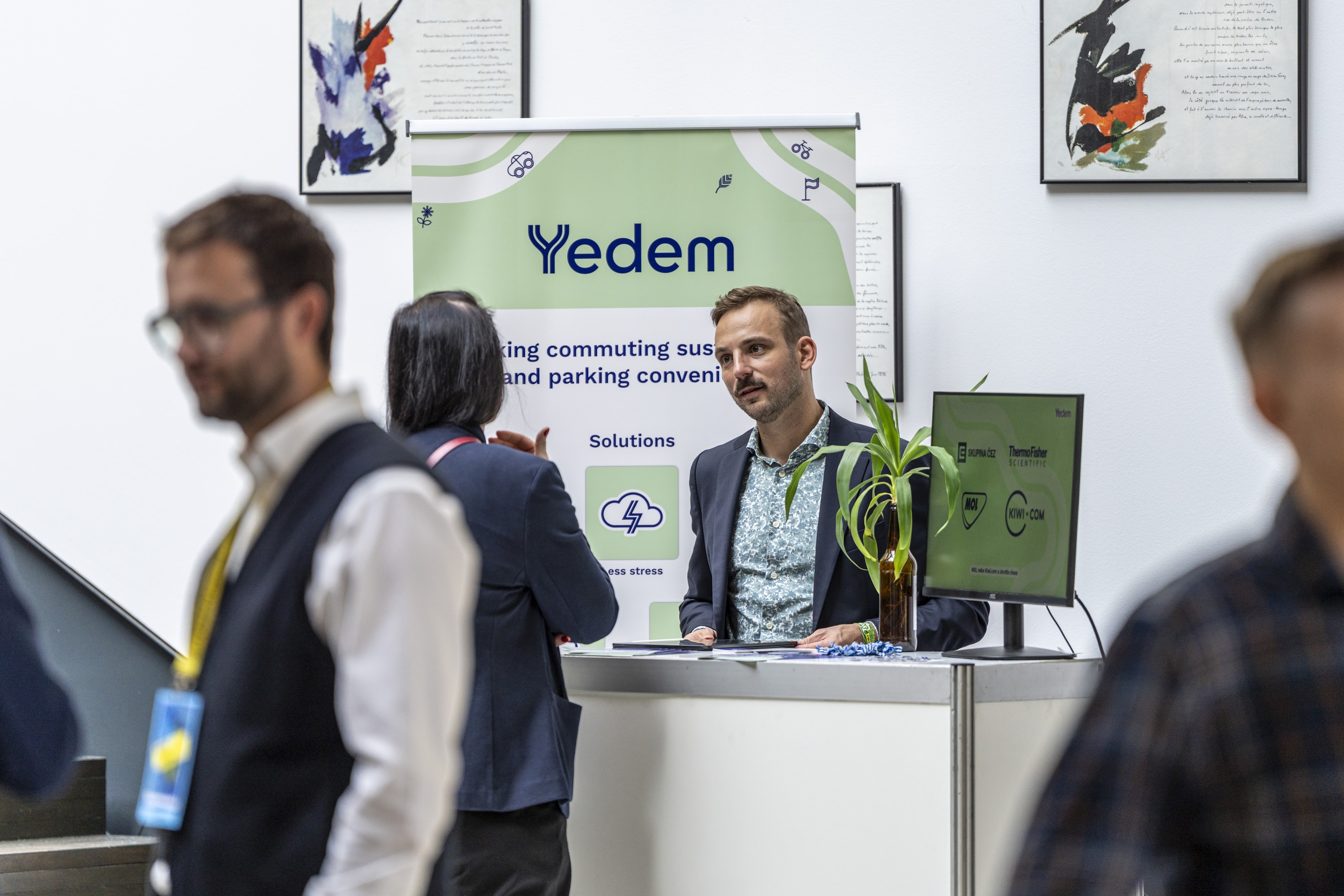 Exhibitor talking with attendees at a conference sponsor booth.