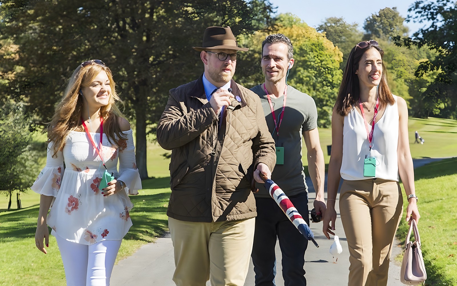 Tour guide leading a small group through the scenic Cotswolds countryside.