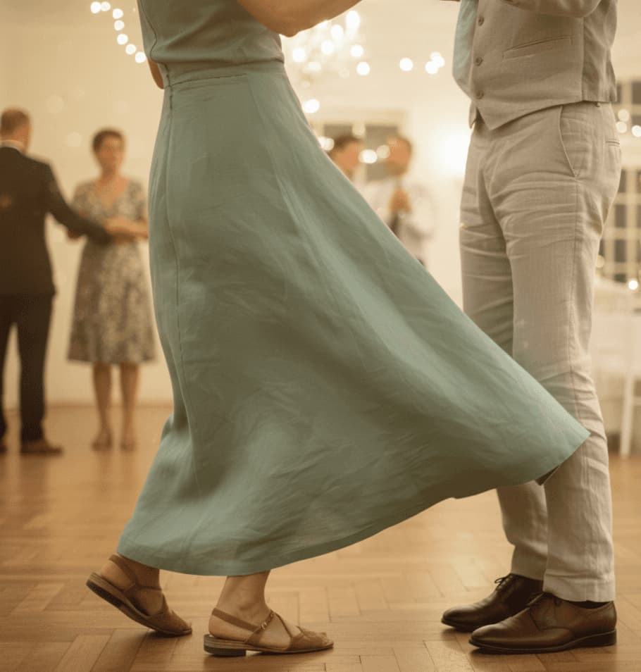 A beautifully set dining table with white tablecloth, cutlery, and fresh greenery in a cozy, well-lit space.