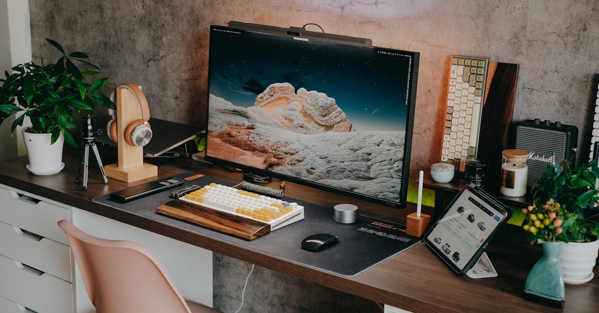 Stylish desk setup featuring a mechanical keyboard, monitor, plants, and tech gadgets.