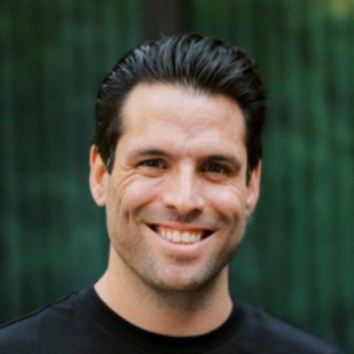 a man with a goatee smiles at the camera