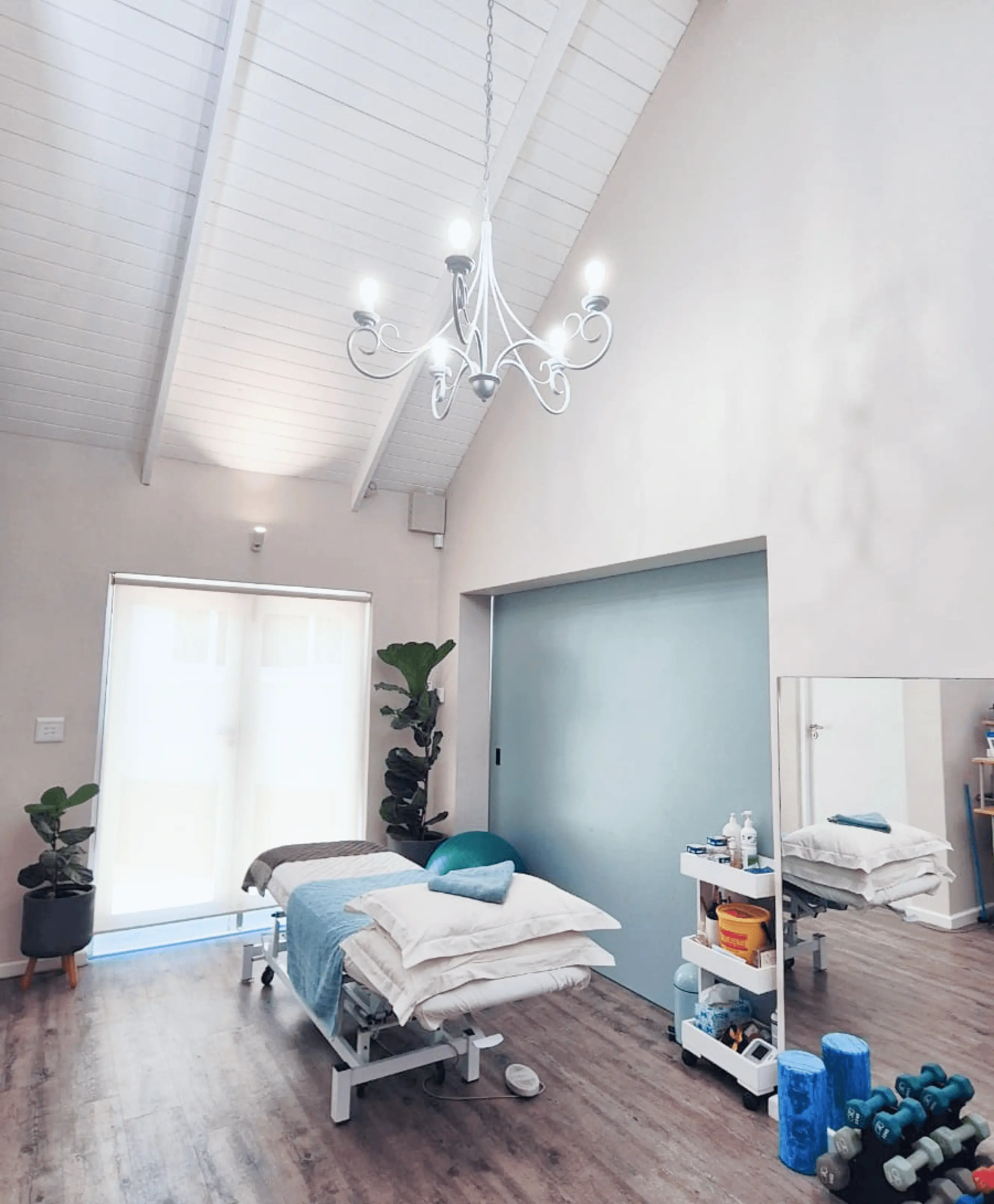 Warm and brightly lit clinic space patience treatment area with an adjustable bed.