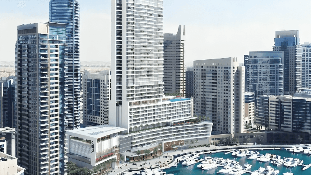 A boat faces the skyline of Dubai, featuring tall buildings against a clear sky.