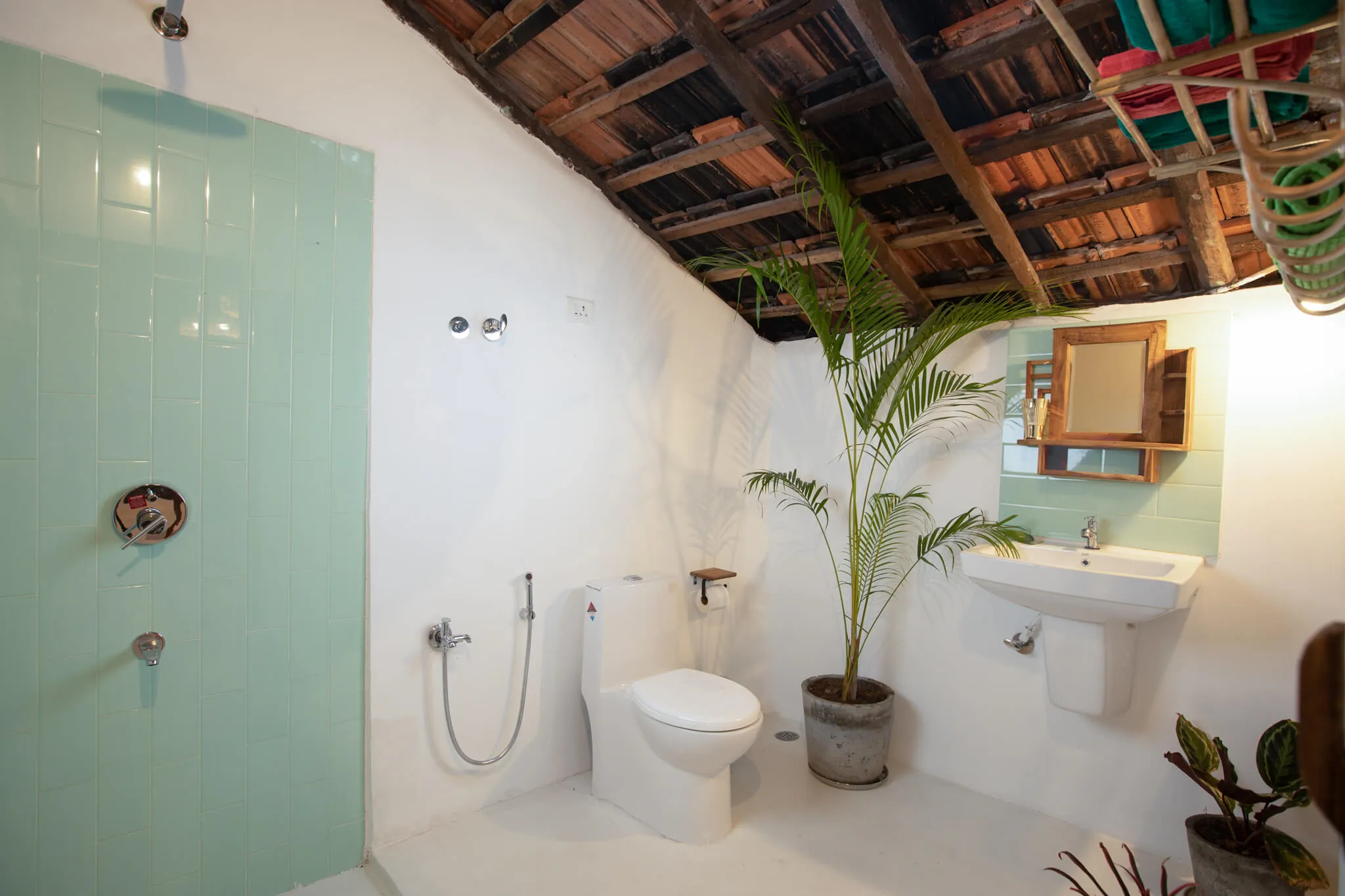 Bathroom with rainfall shower under a thatched roof at Casa Jaali