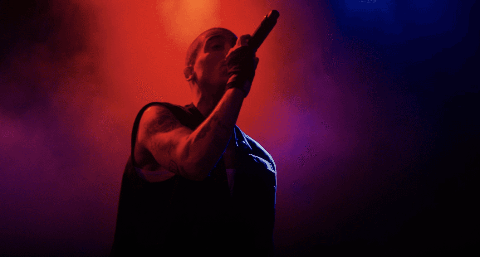 A talent recruiter with a soft smile working on her laptop in the office. The angle is on her face so we can't see what's is on the screen. She is wearing a blazer 
