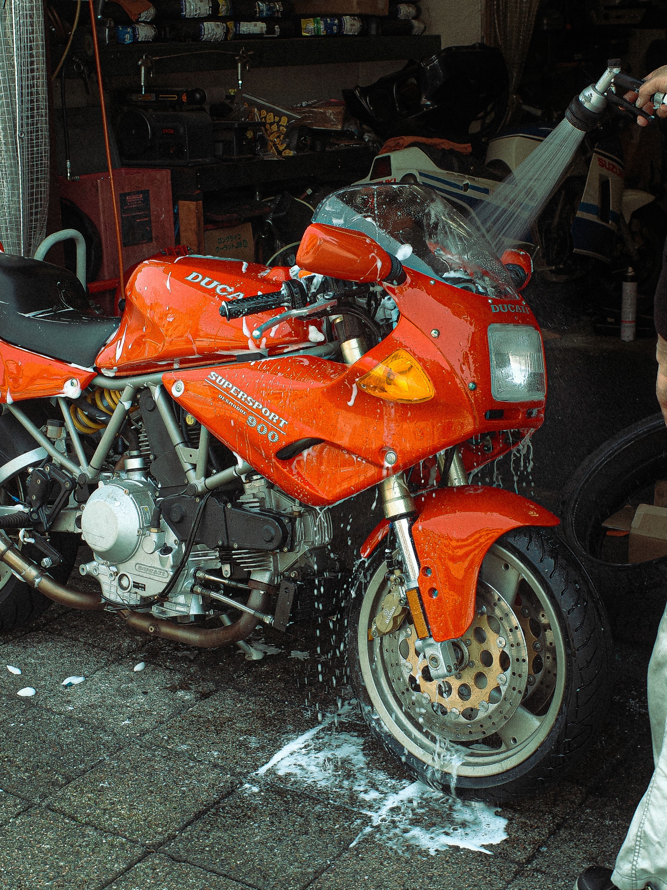 A close-up of a pink cocktail in a martini glass, set against a nighttime background with soft, blurred colors.