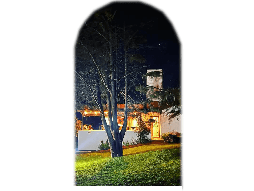 A woman sits cross-legged with eyes closed, wearing a white blouse and a long purple skirt, looking serene.