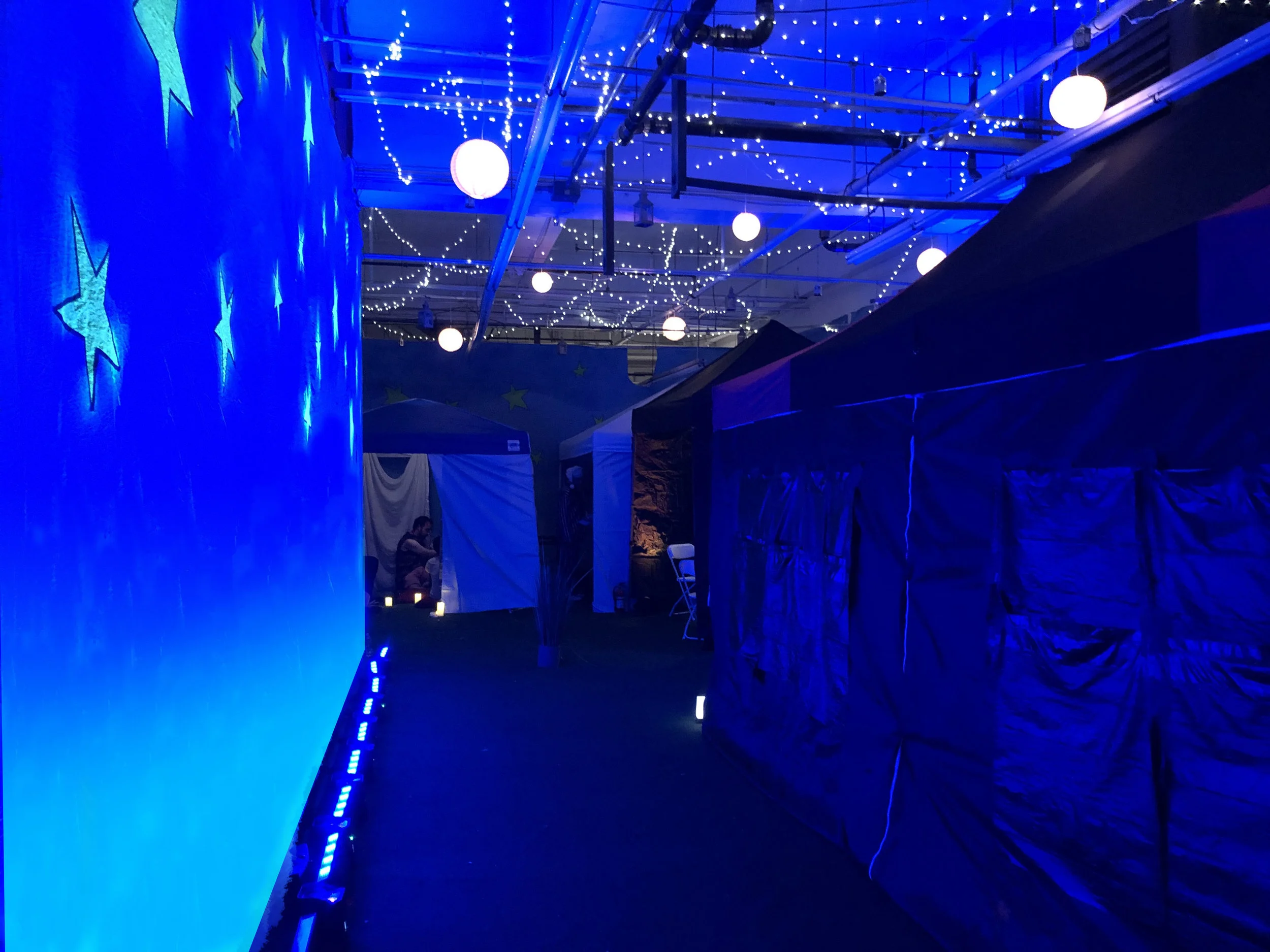 Blue lighting and suspended stars in a Night Cafe dream space.