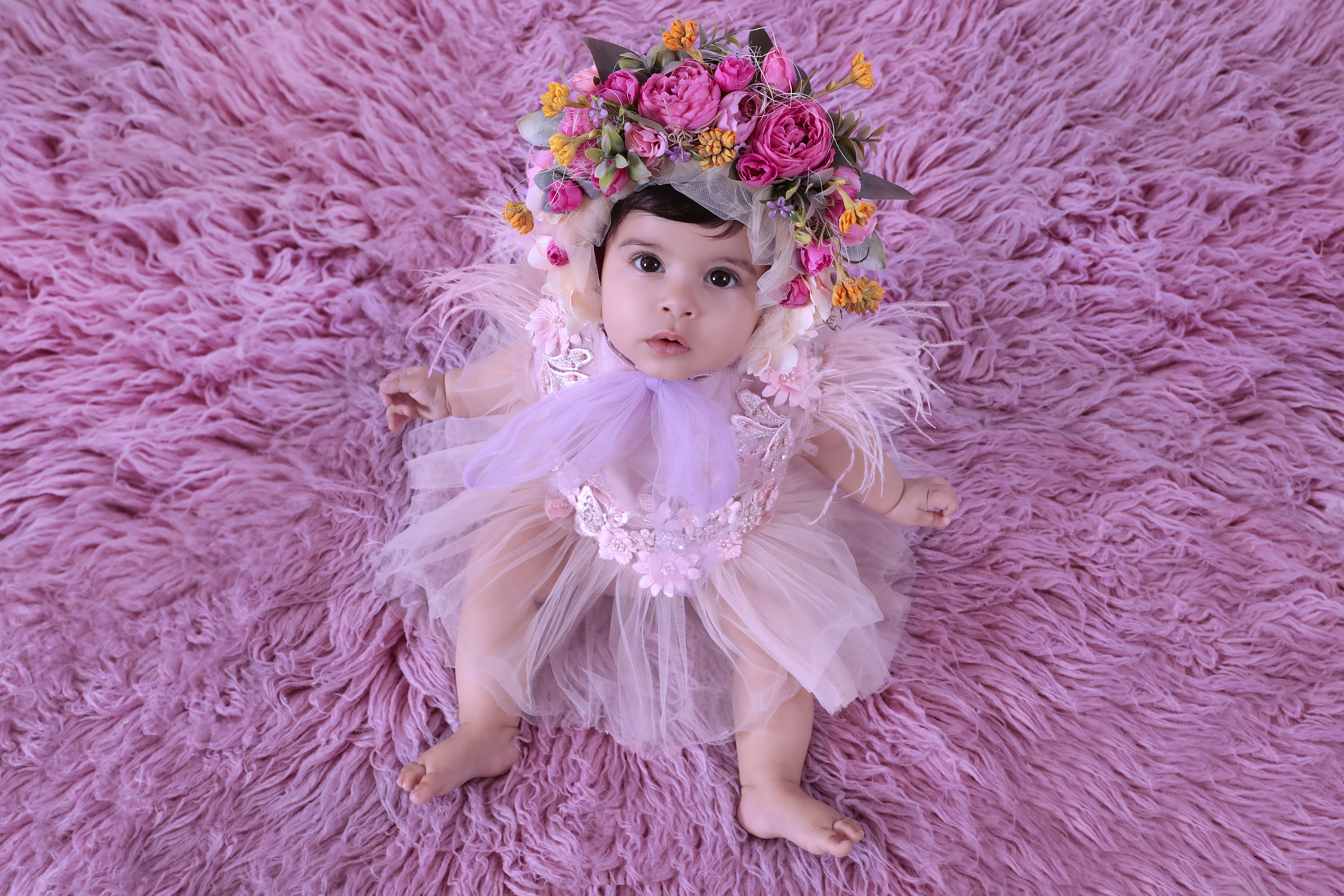 Top view of a baby girl dressed in pink ruffles for a newborn photoshoot.