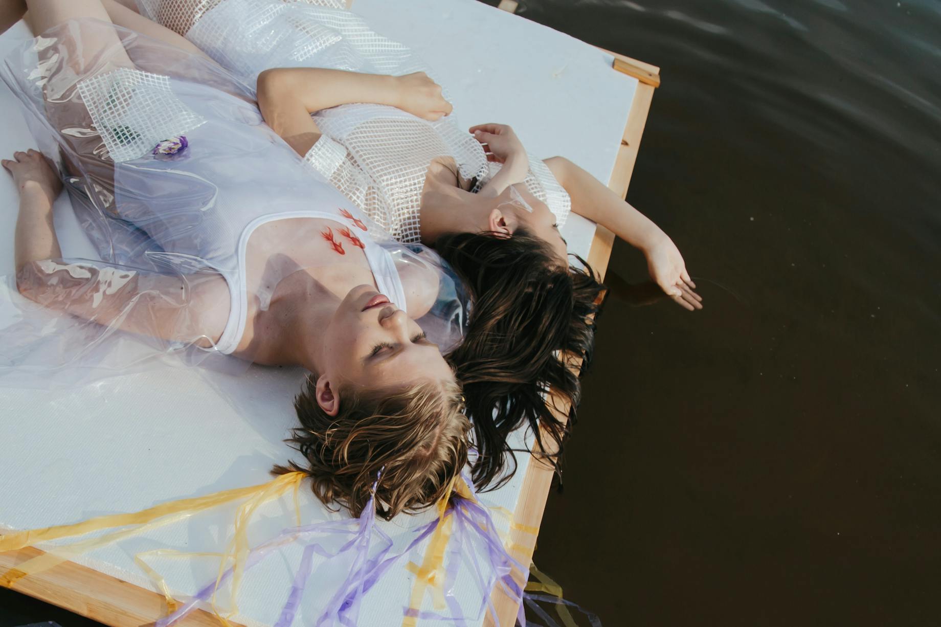 Women laying down on wooden platform near the sea