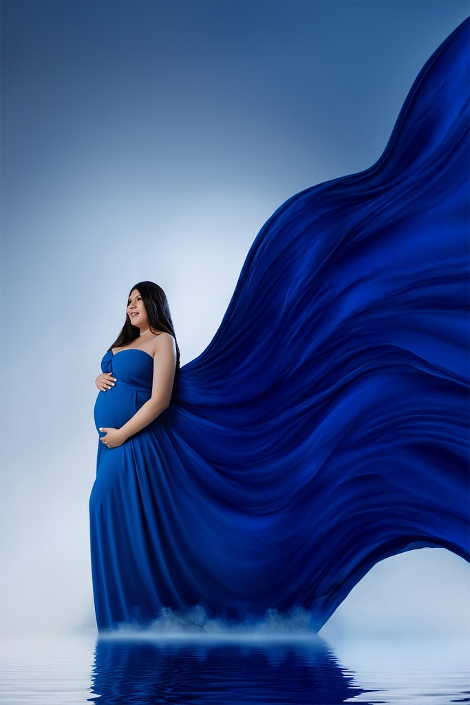 Elegant maternity photoshoot with airy fabric and movement — artistic studio style.