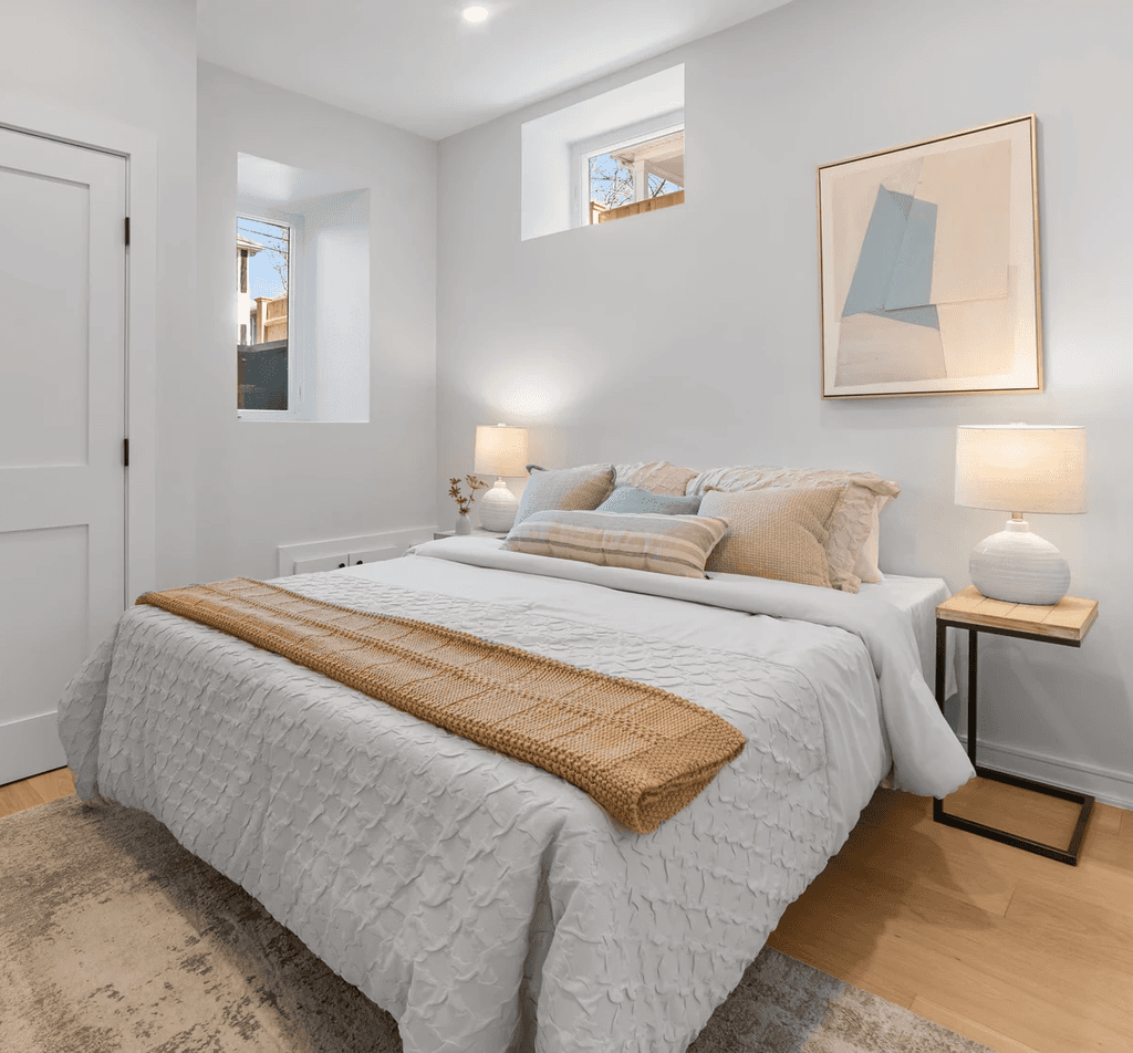 Modern bathroom featuring wooden cabinetry, a bathtub, a sleek sink, and natural light from a window.