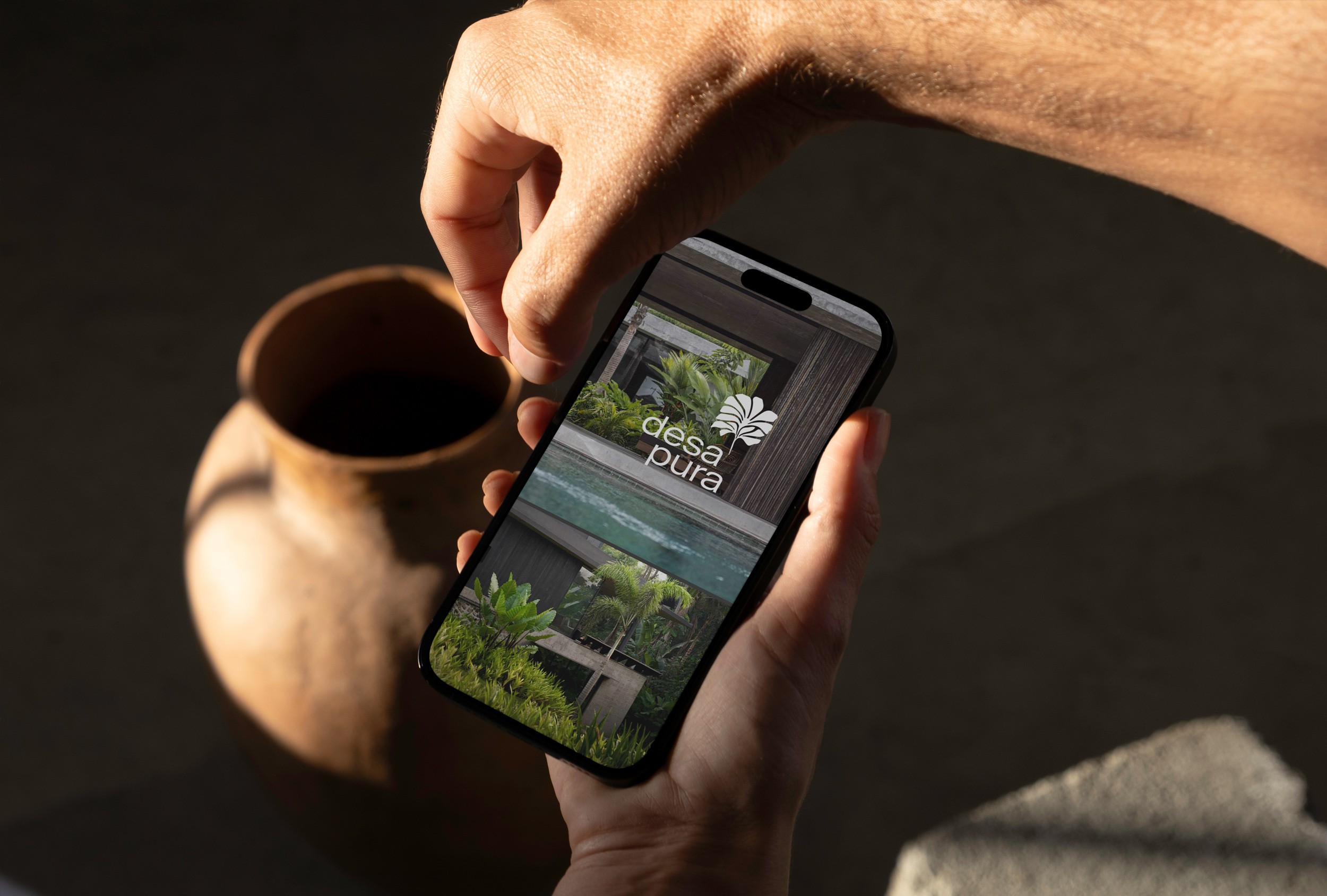 Logo des Desa Pura Wohnprojekts auf einem Smartphone, das Natur, Gemeinschaft und modernes Wohnen symbolisiert.