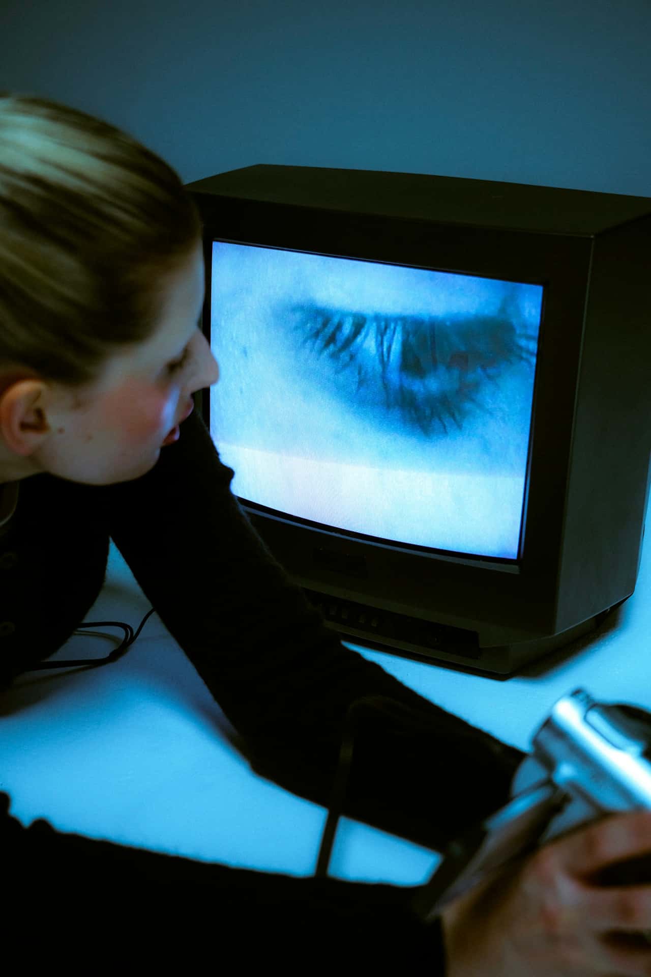 eine Frau, die in einen alten Fernseher schaut