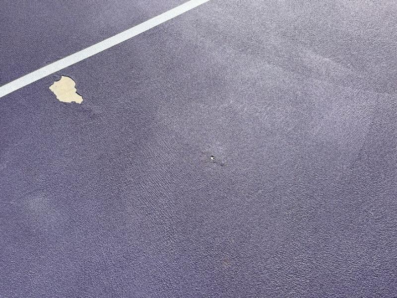 Peeling coating on a purple tennis court at Thunder Basin High School, Wyoming, before resurfacing