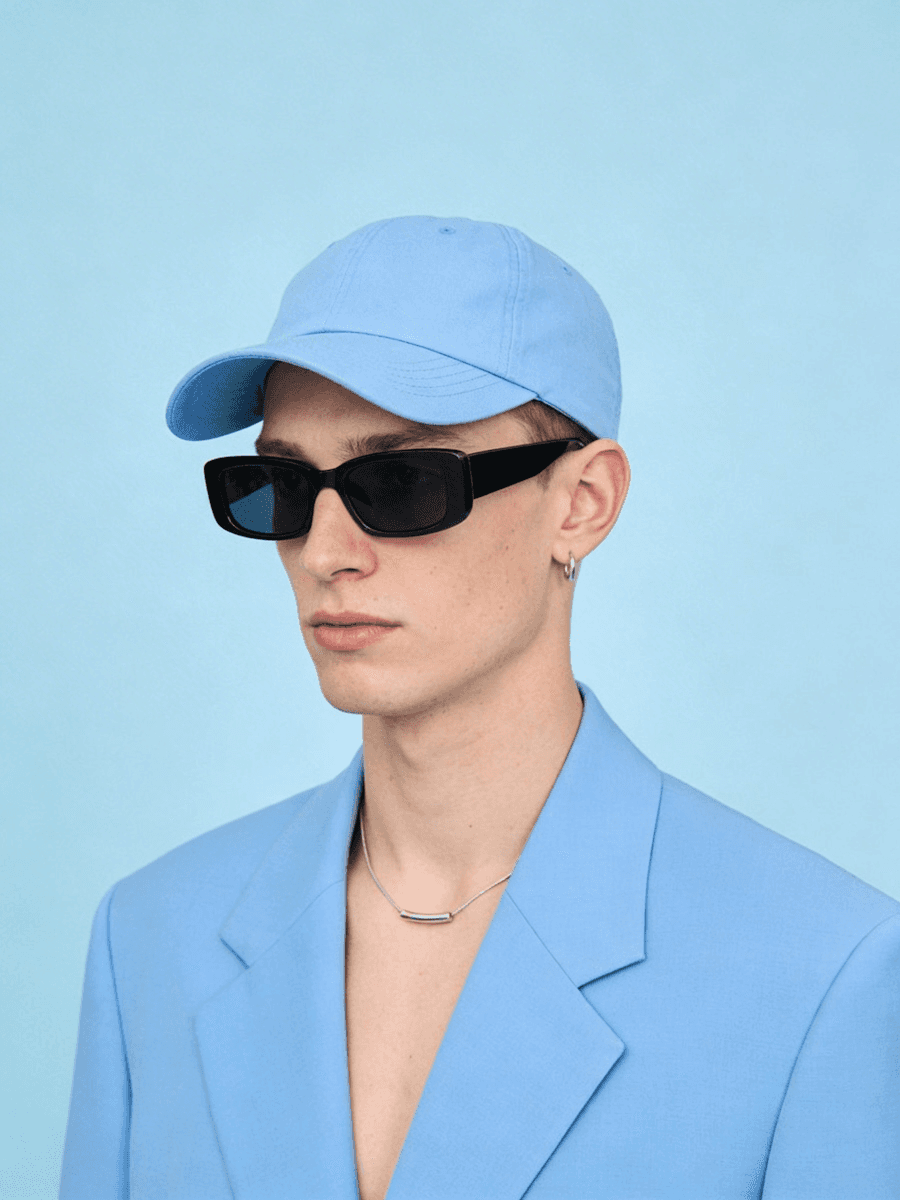 Man holding books with arms crossed in studio.