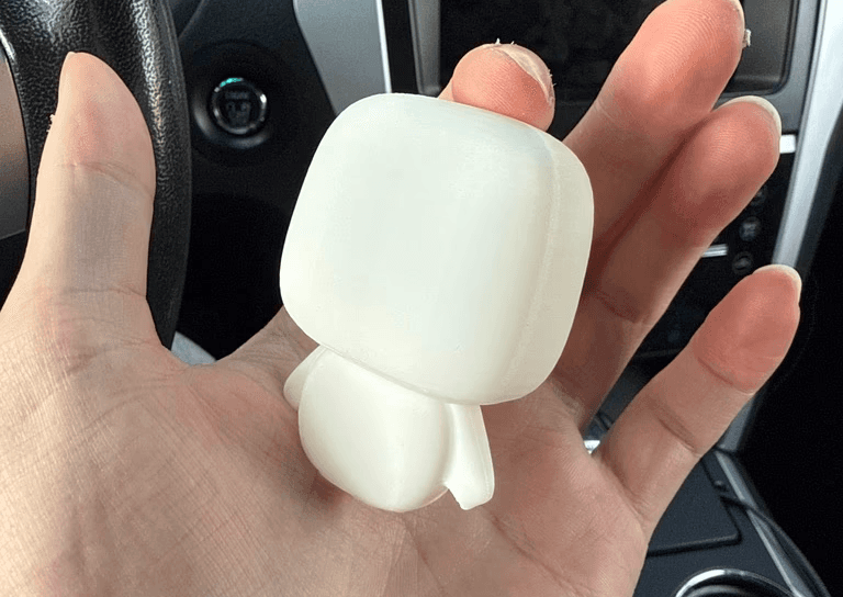 First 3D-printed test print of oscar's rough shape, unpainted, held in hand for a real-scale check