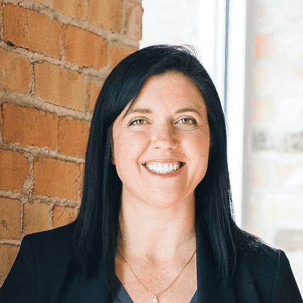 woman standing by wall holding mug