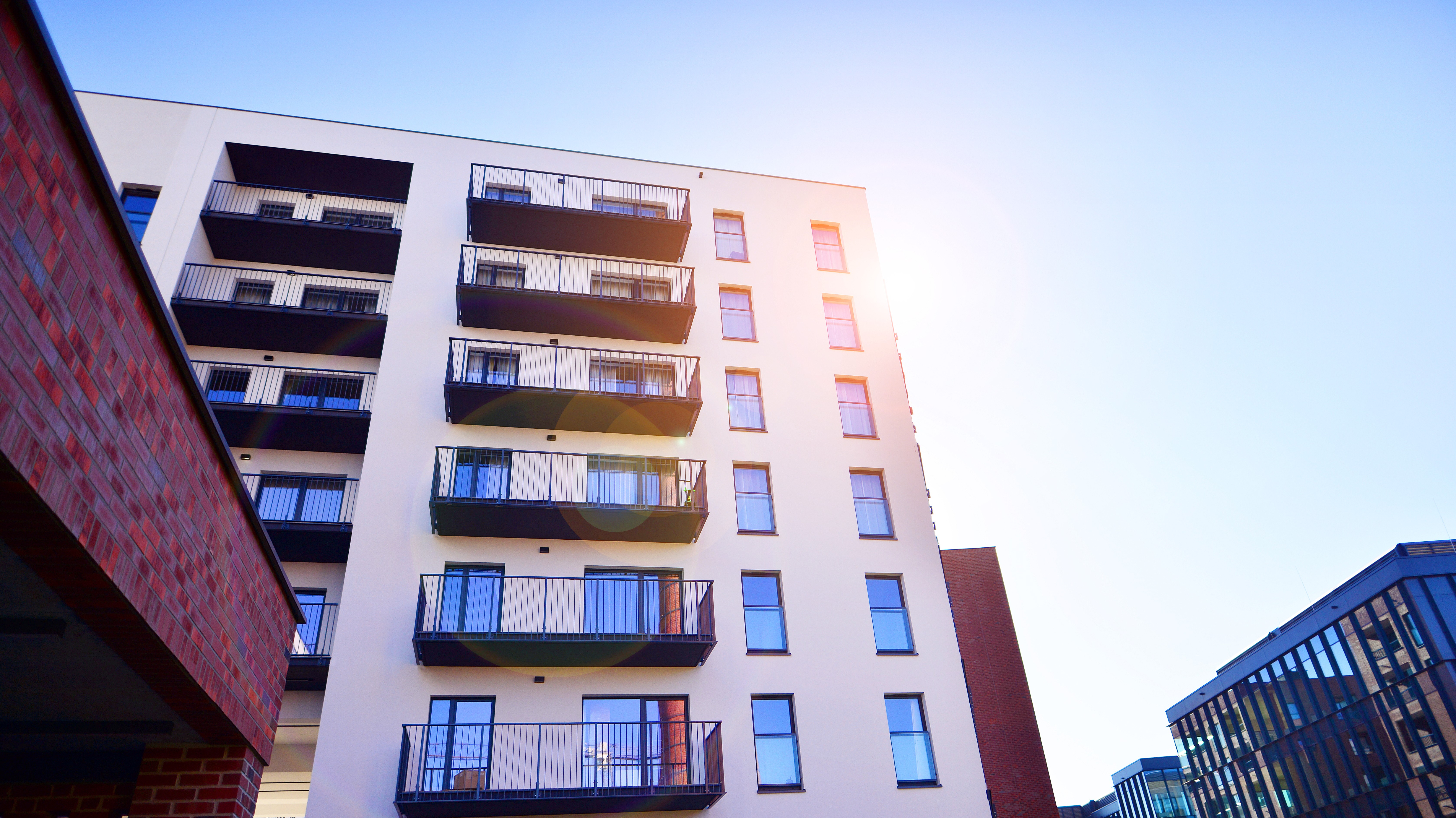 Modern multi-story residential apartment building with balconies, representing a project protected by M-Fire Suppression