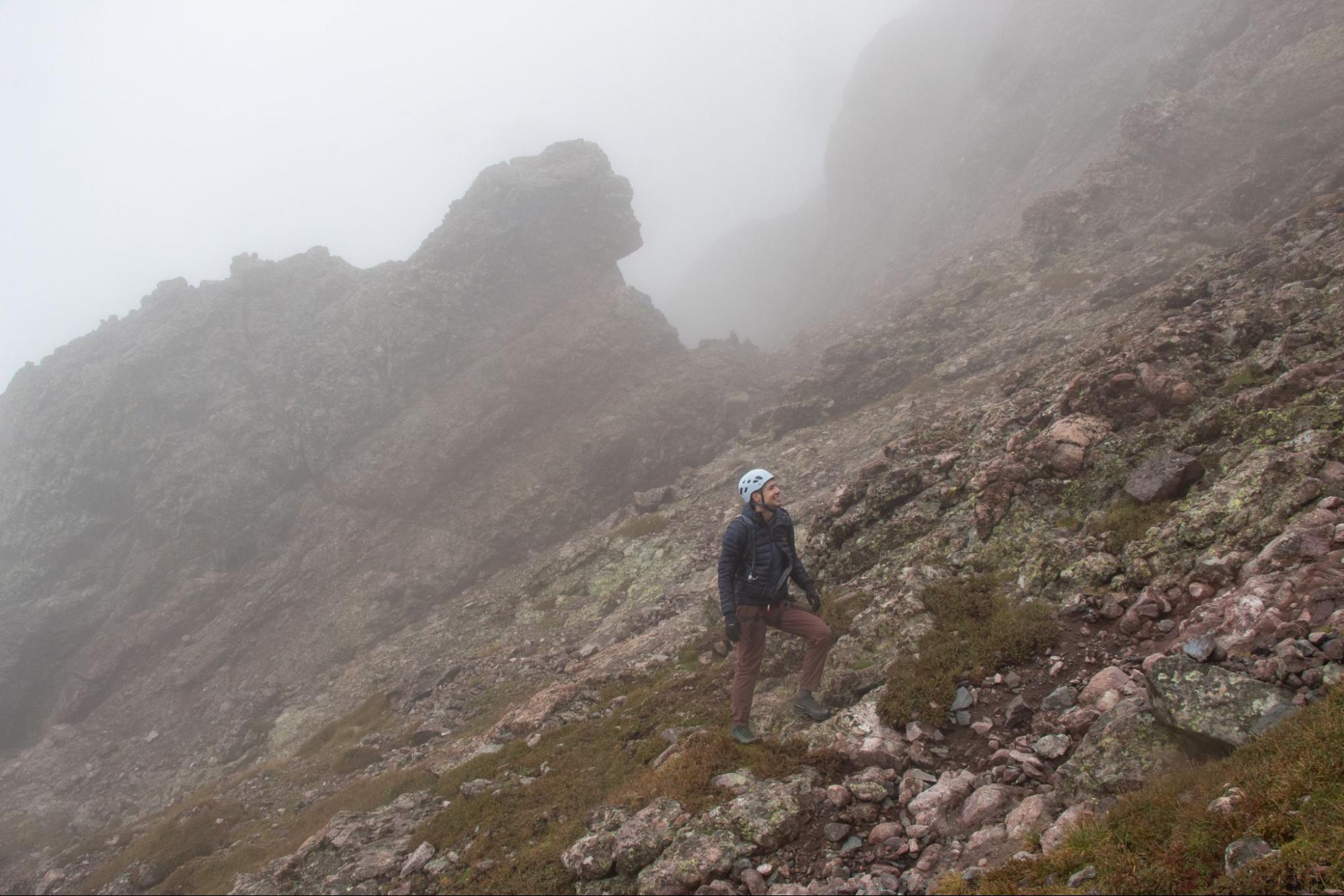 Climber looks up through the fog partway through Crestone Traverse