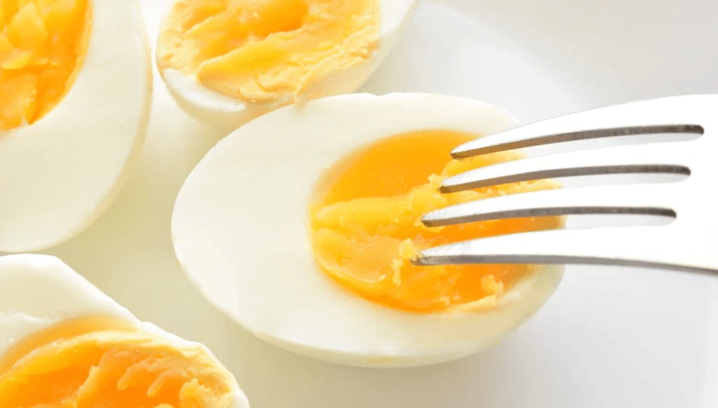 Halved Boiled Eggs with Fork on White Plate