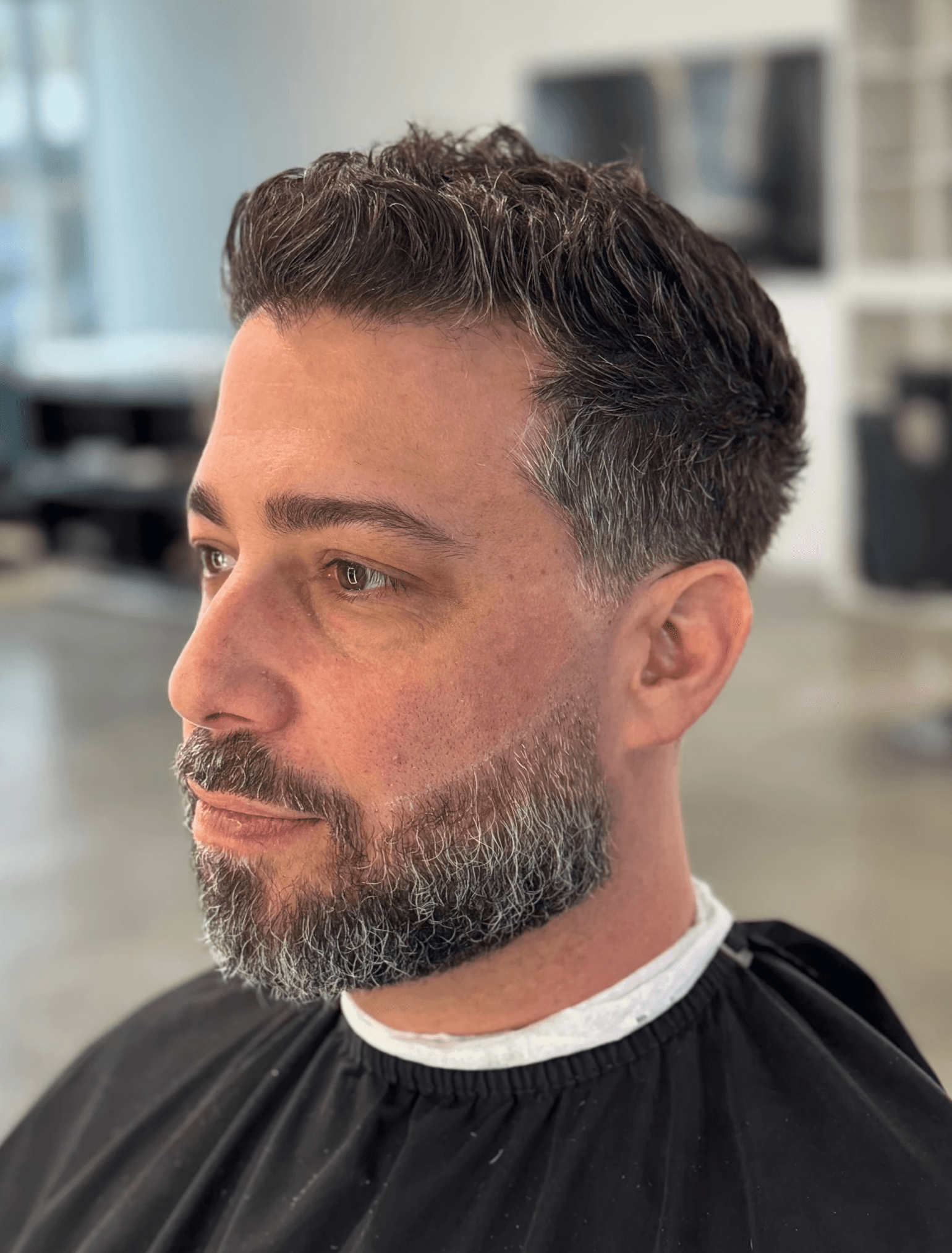 Salt-and-pepper grooming with tailored beard trim and professional fade haircut by Courtney Palmore in West Hollywood. Califorina Los Angeles