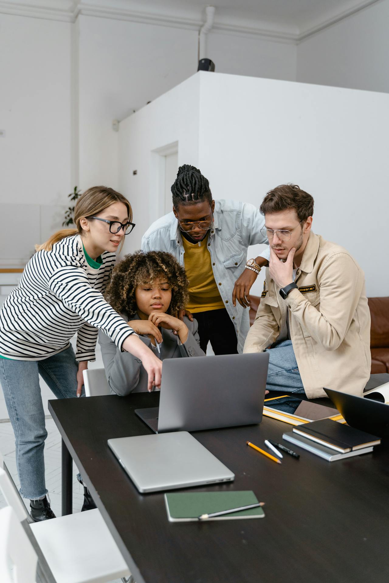 People gathered around a laptop in discussion, suggesting coordinated incident response.