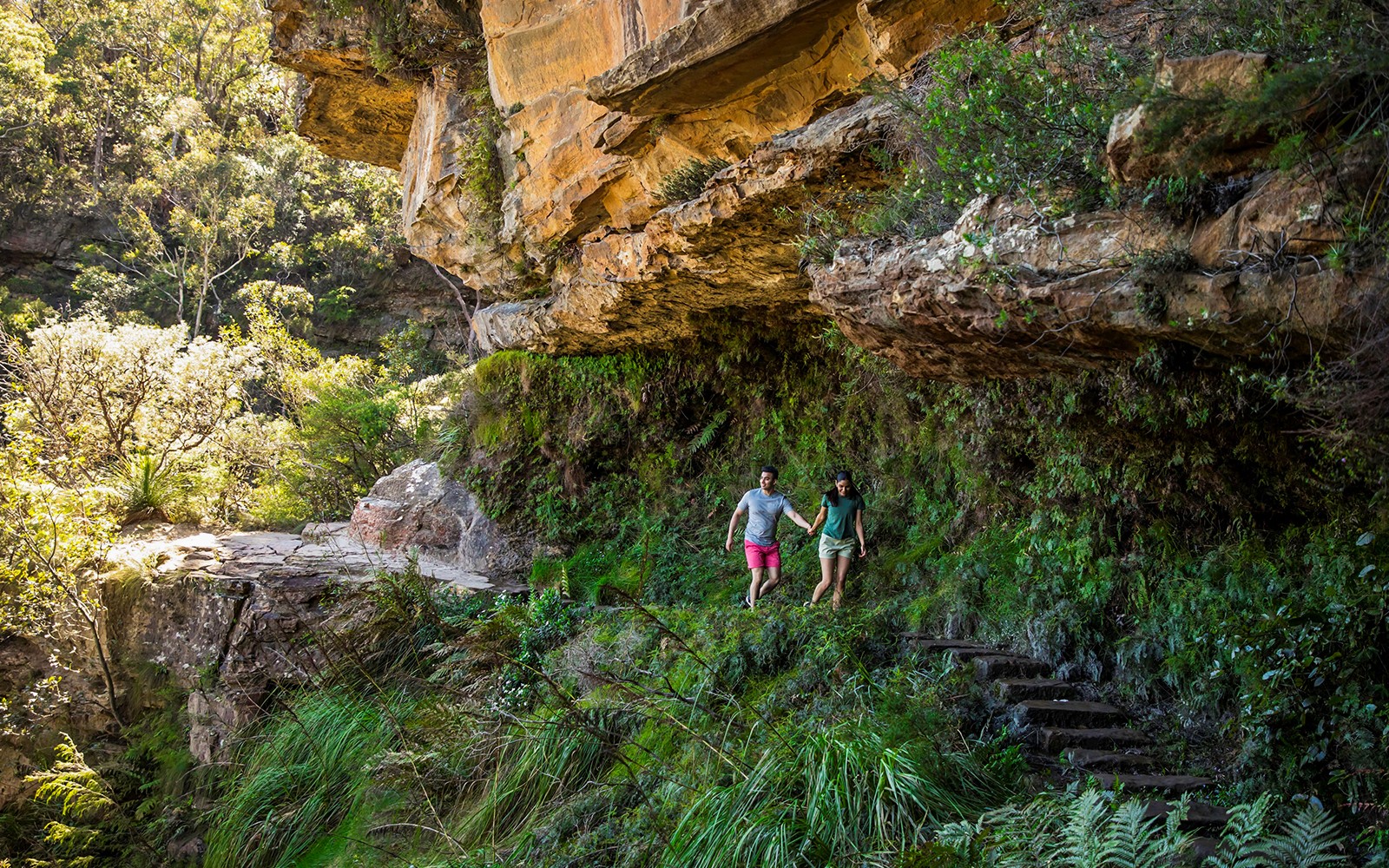 Couple walking on secluded bush trail during Blue Mountains Sunset & Wilderness Day Trip from Sydney.