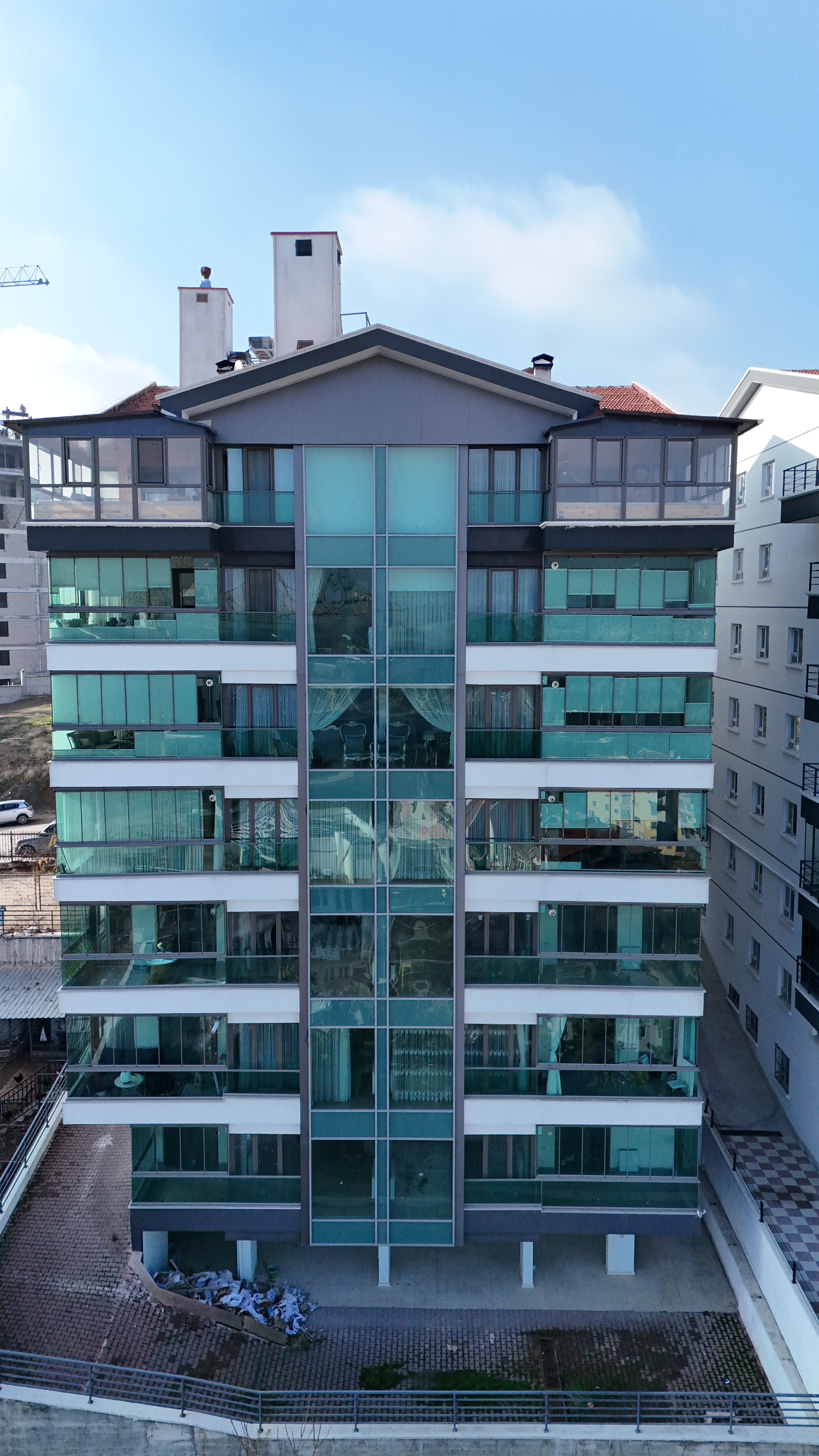 Outdoor lounge under a wooden pergola, draped linen curtains, beige cushions, ocean backdrop, palm shadows dancing on the walls, serene luxury.